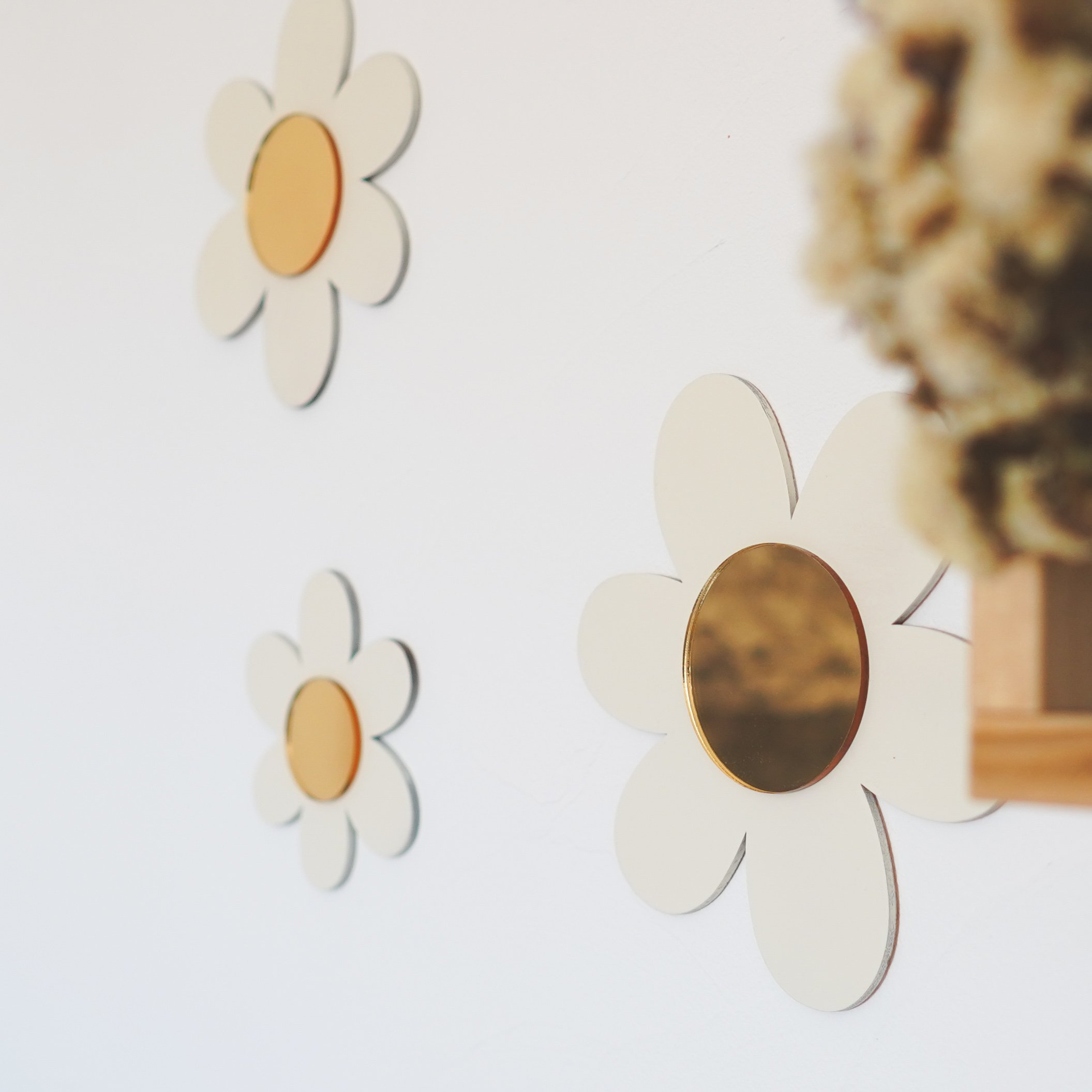 Décoration murale avec des fleurs stylisées blanches avec cœur doré."}