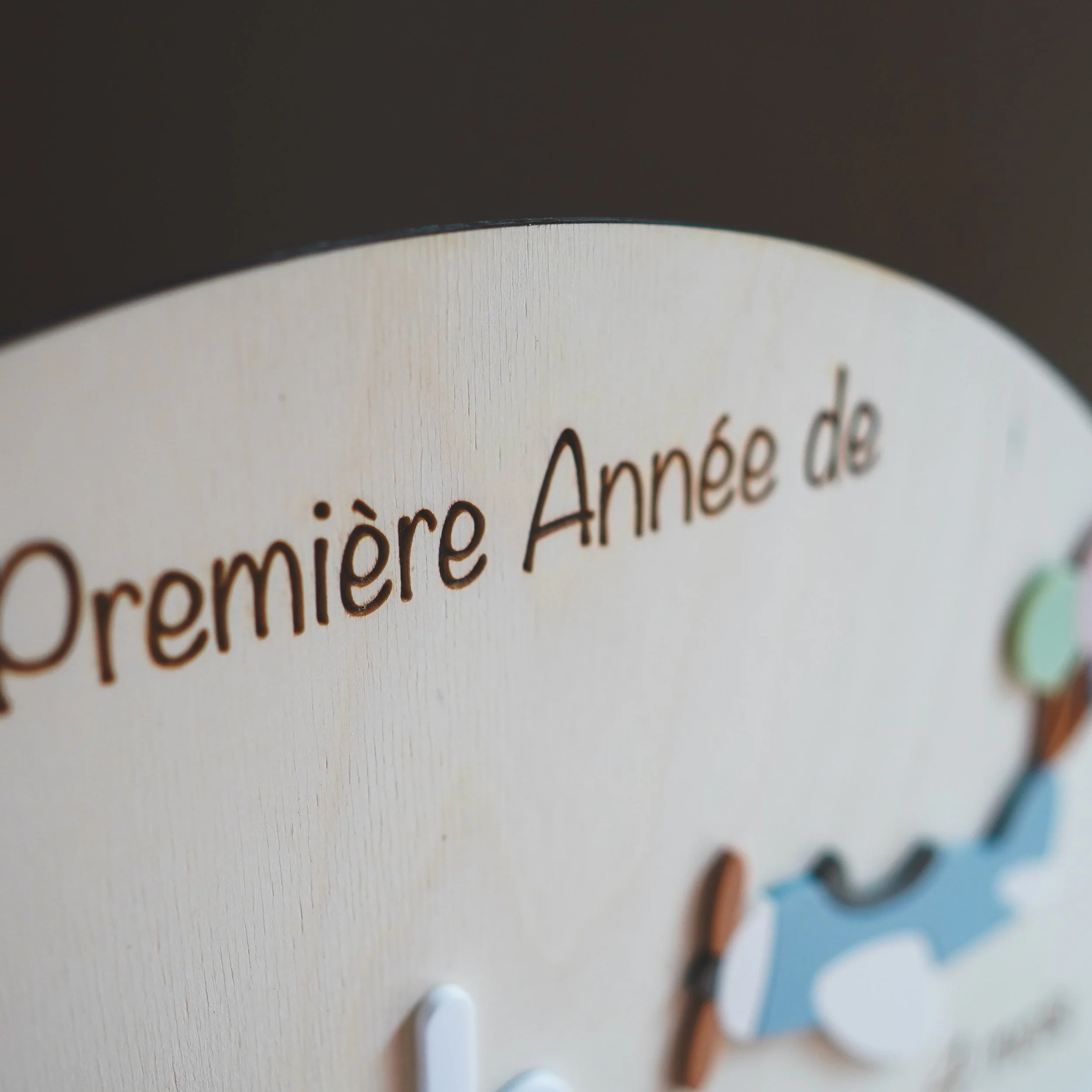 Inscription La Première Année de gravée en haut du panneau en bois