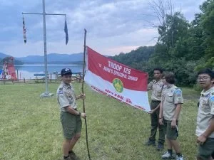 Scouts holding Troop 128 flag on a homemade flagpole