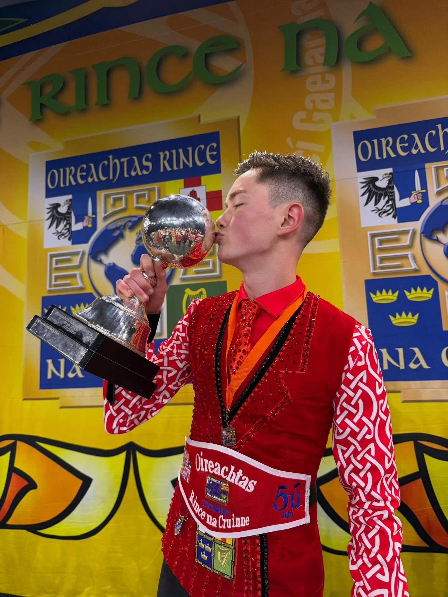 A young boy celebrating his 5th place at World Irish Dance Championships 2026 holding globe.