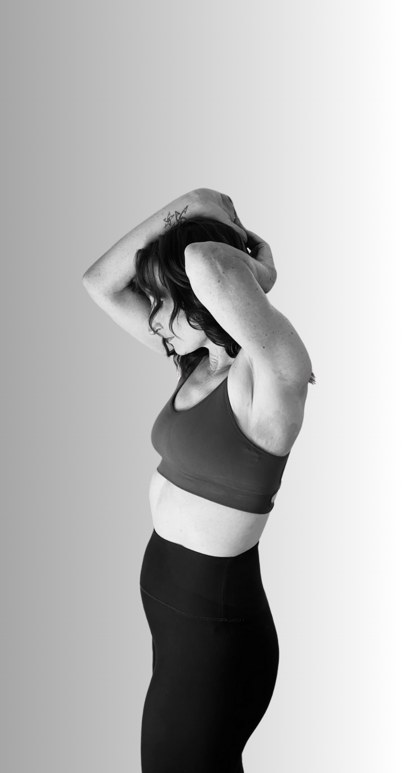 A woman in athletic wear with arms raised behind her head, balancing and stretching, against a gradient background.