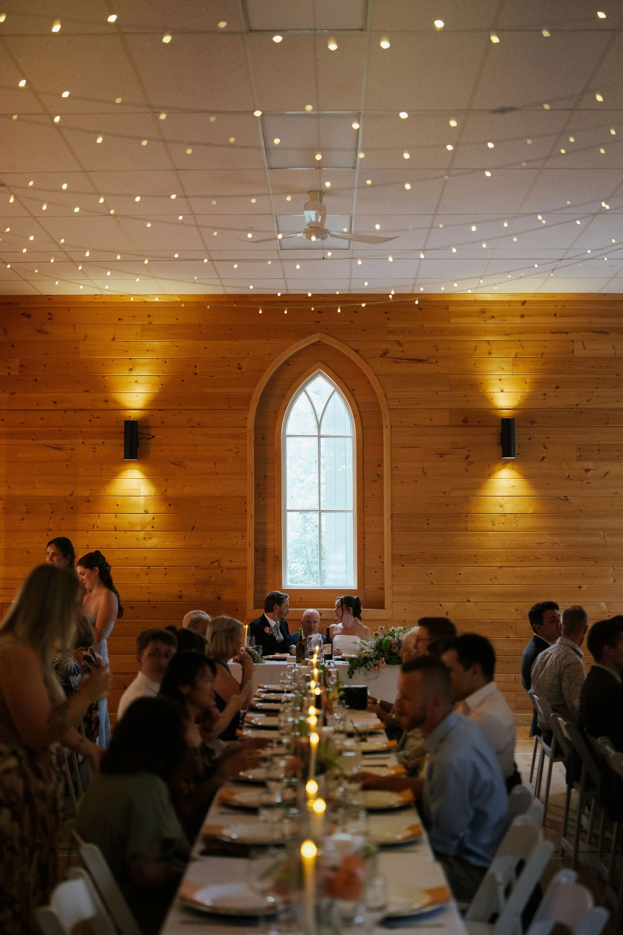 Warm lighting and florals throughout the Lake Country wedding reception