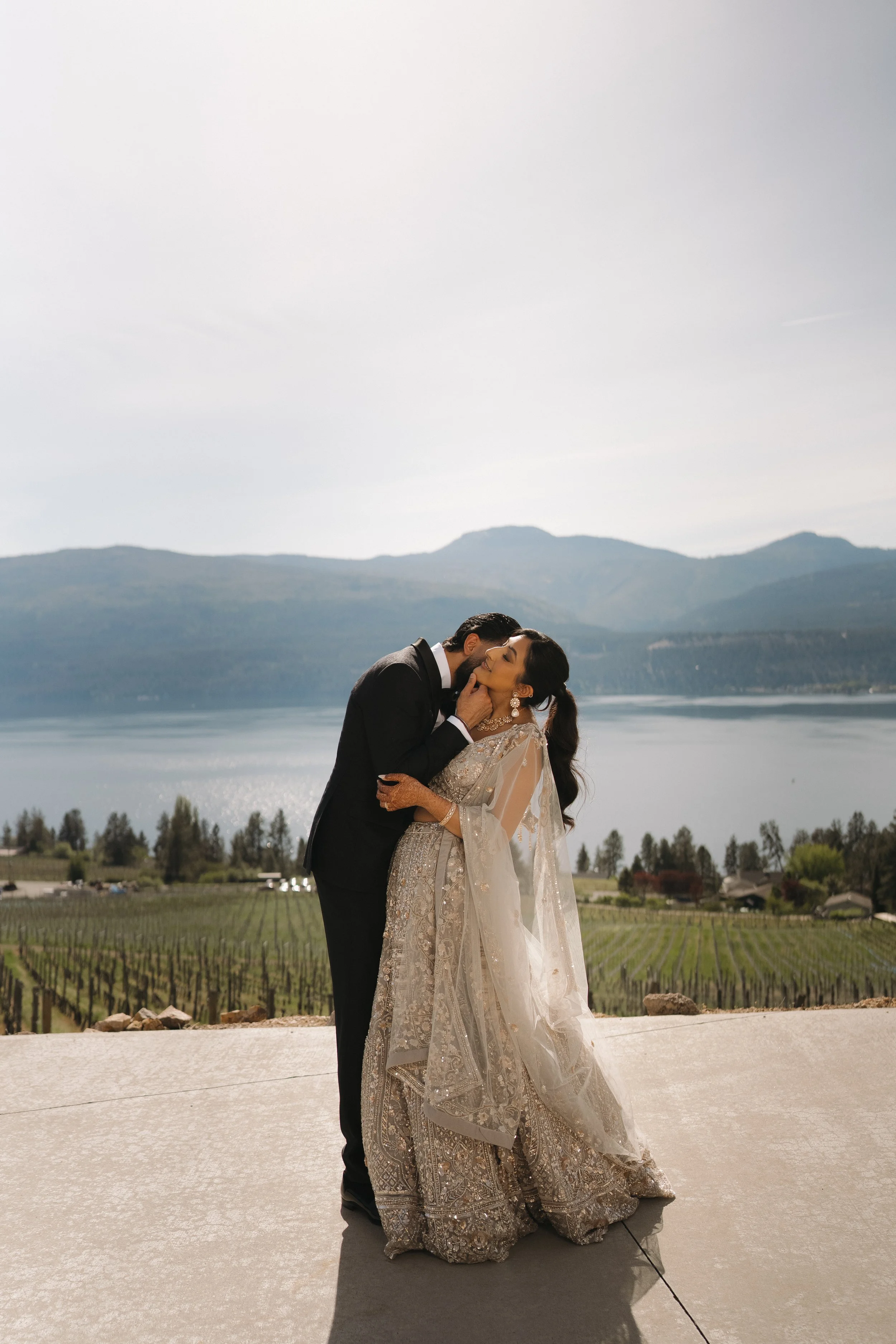 Reena & Nov standing together with views of the Okanagan landscape