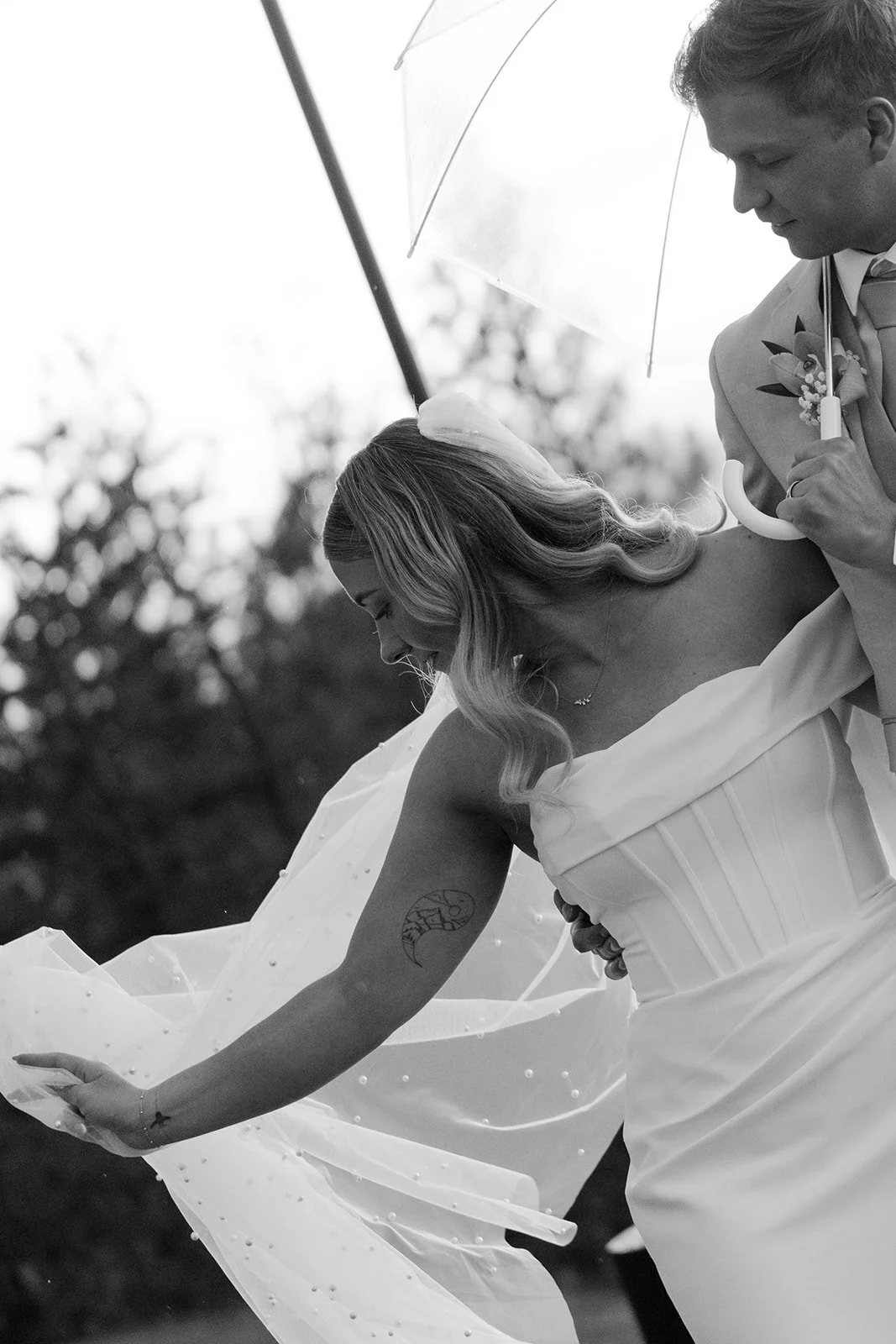 Bride and groom walking arm in arm across the grass