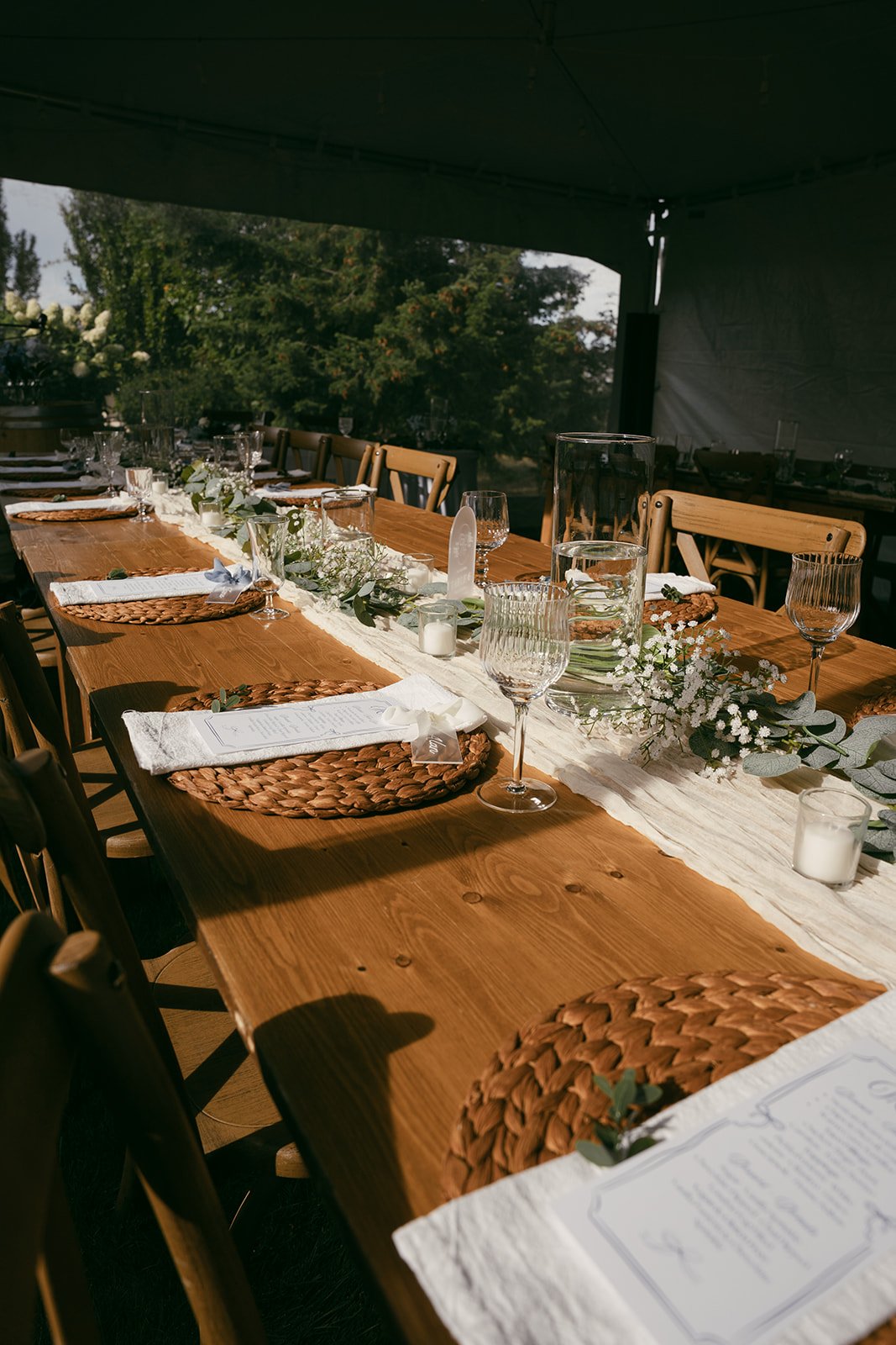Place settings and glassware on a long outdoor table