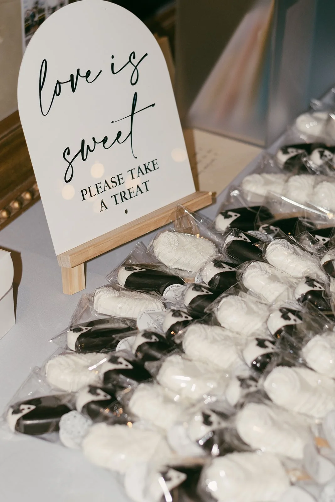 Bride and groom cakesicles lined up on a display table