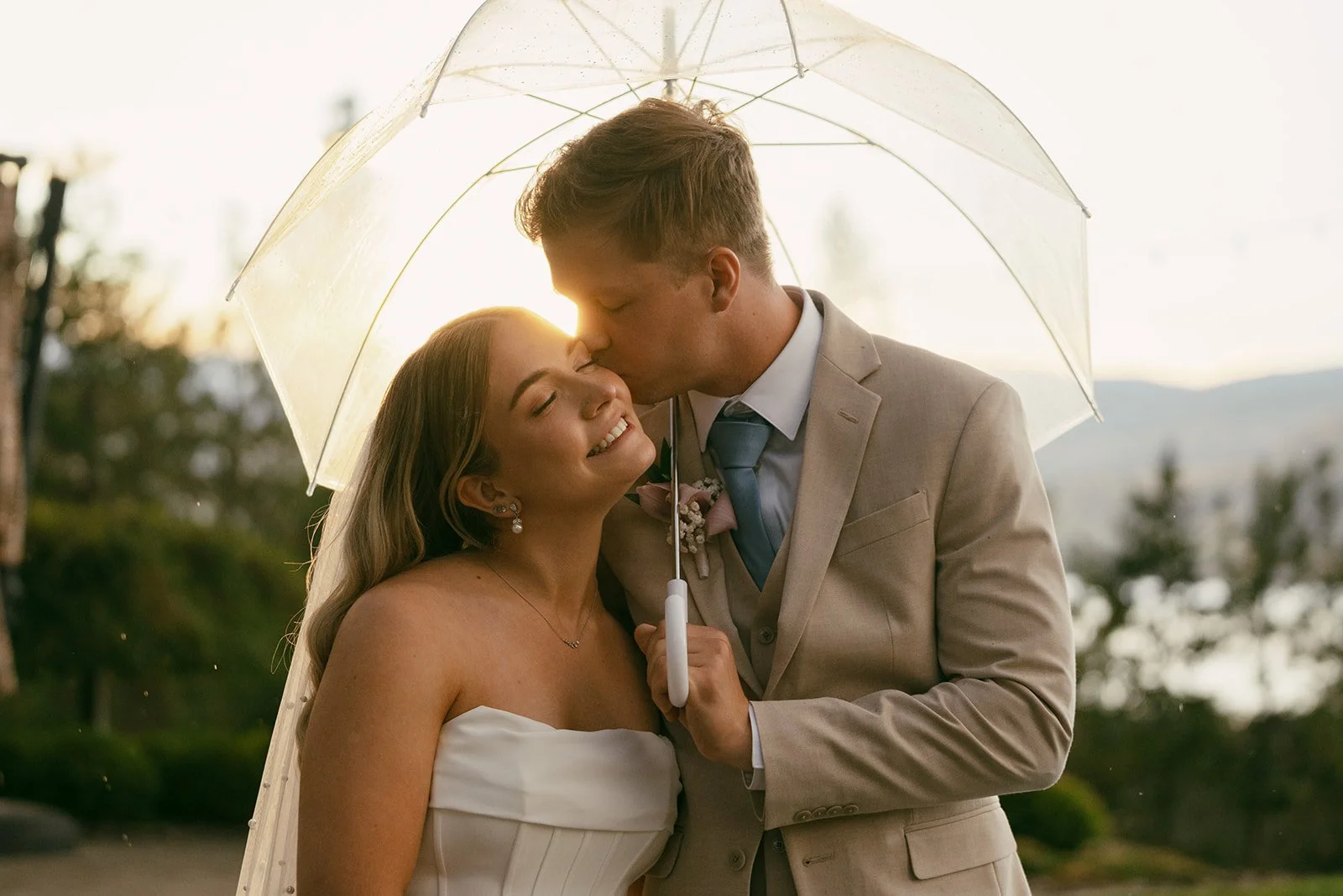 Bride and groom laughing together as the rain begins to fall