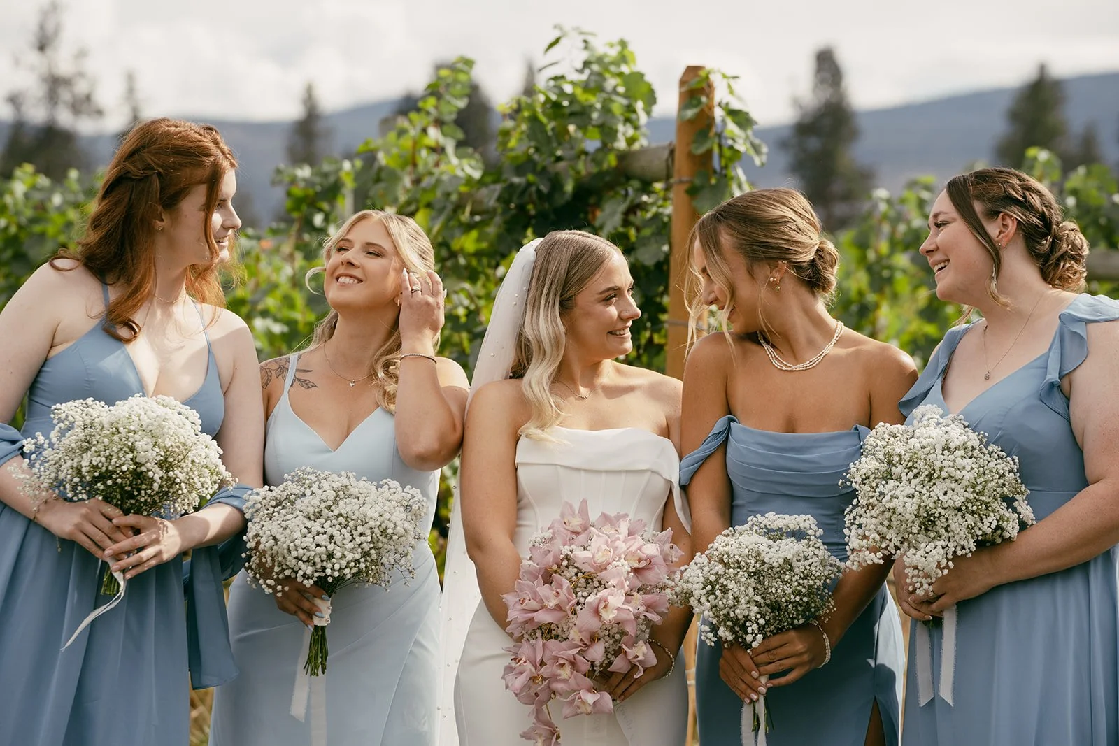 Bridesmaids laughing together on the grass