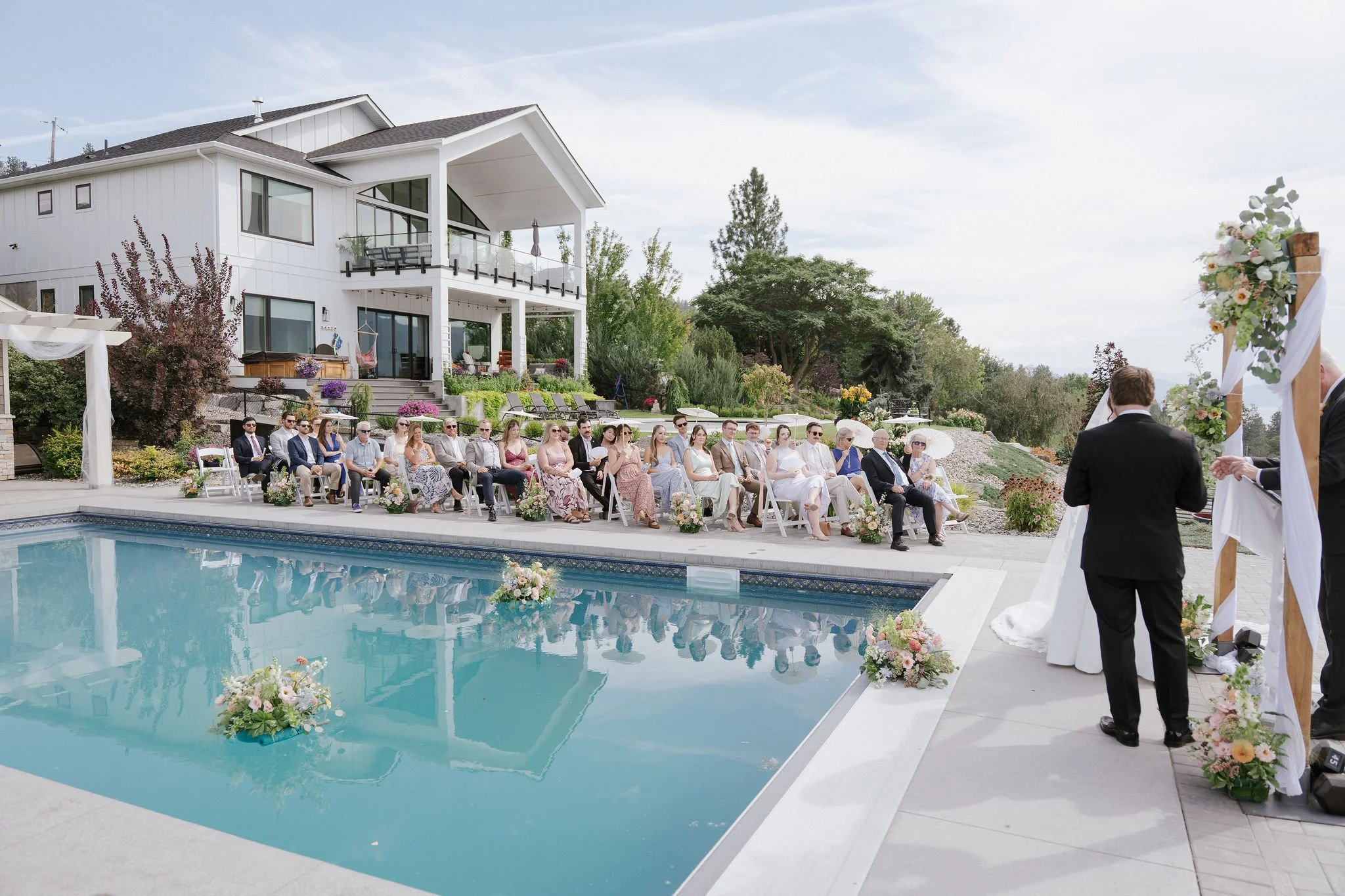 Guests gathered around the pool for Cat & Cam’s wedding ceremony 