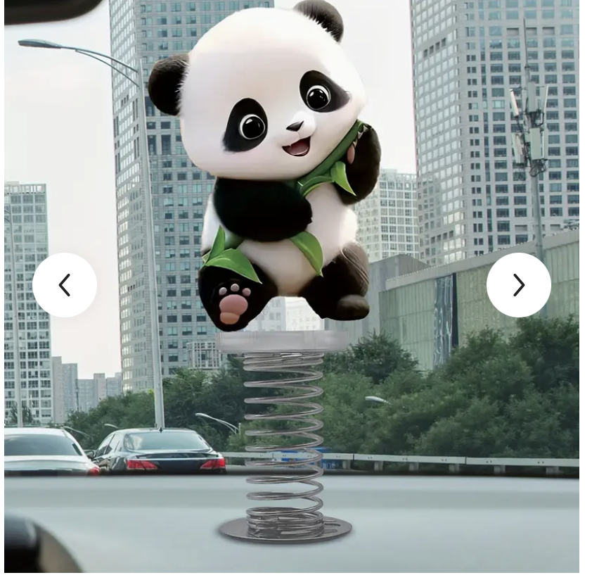 A panda-shaped air freshener or toy attached to a spring, sitting on a car dashboard with a city skyline and traffic in the background.