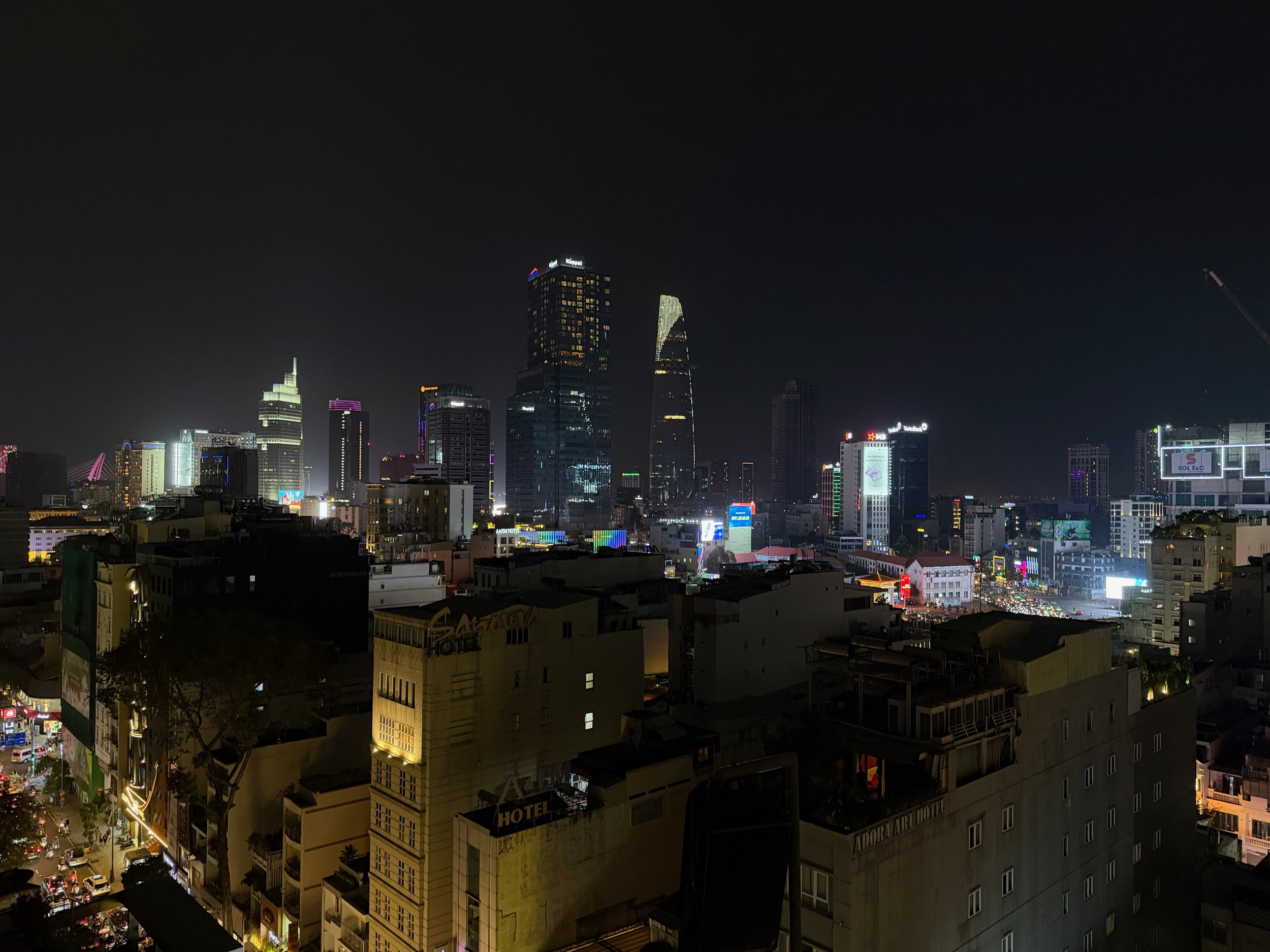 Night view of a city skyline with illuminated skyscrapers and buildings.