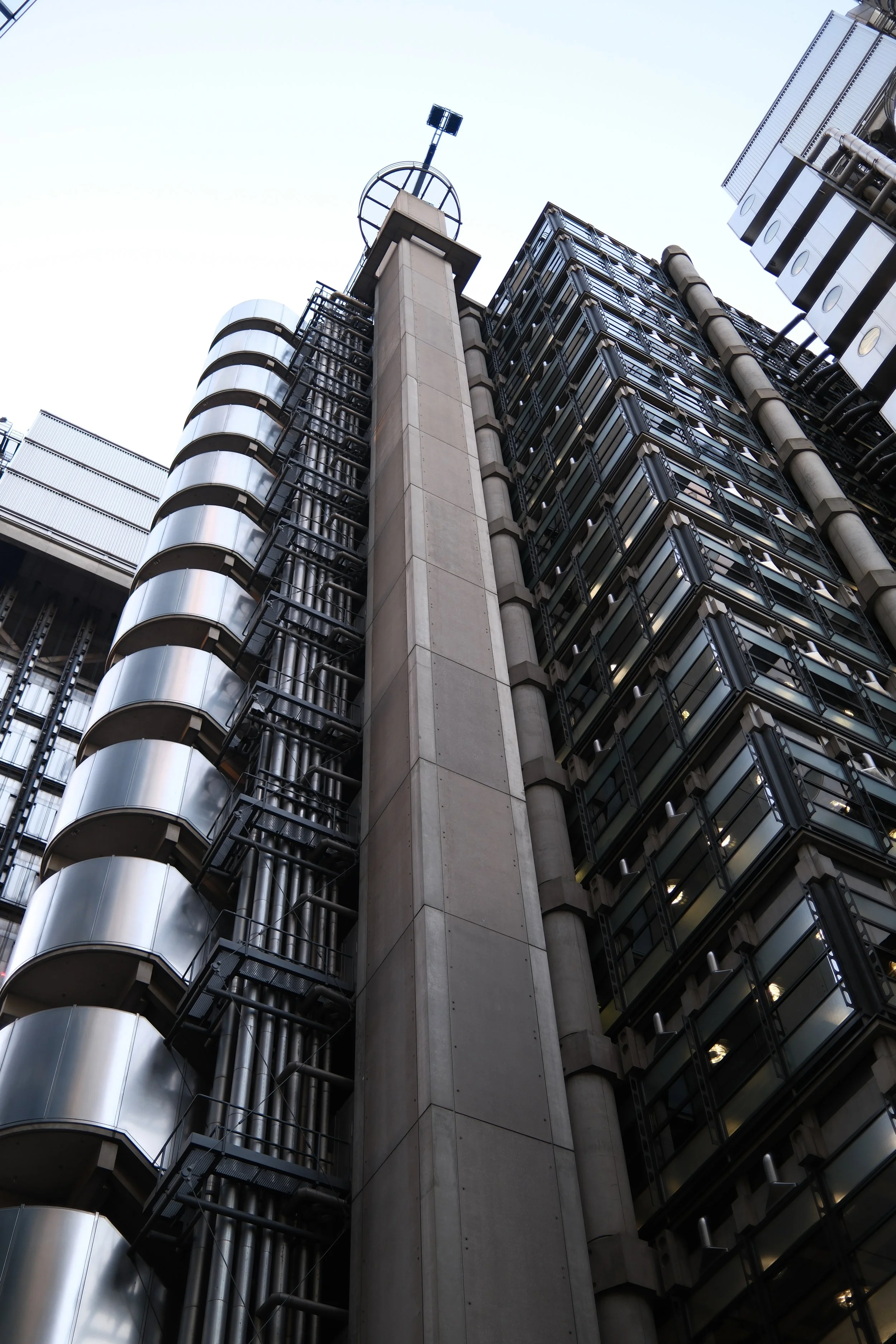 Looking up at a modern glass and metal skyscraper with a clear sky in the background.