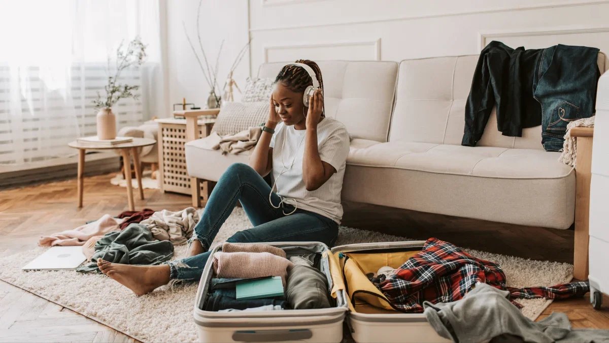 Traveler packing a suitcase at home with clothes laid out for an upcoming trip