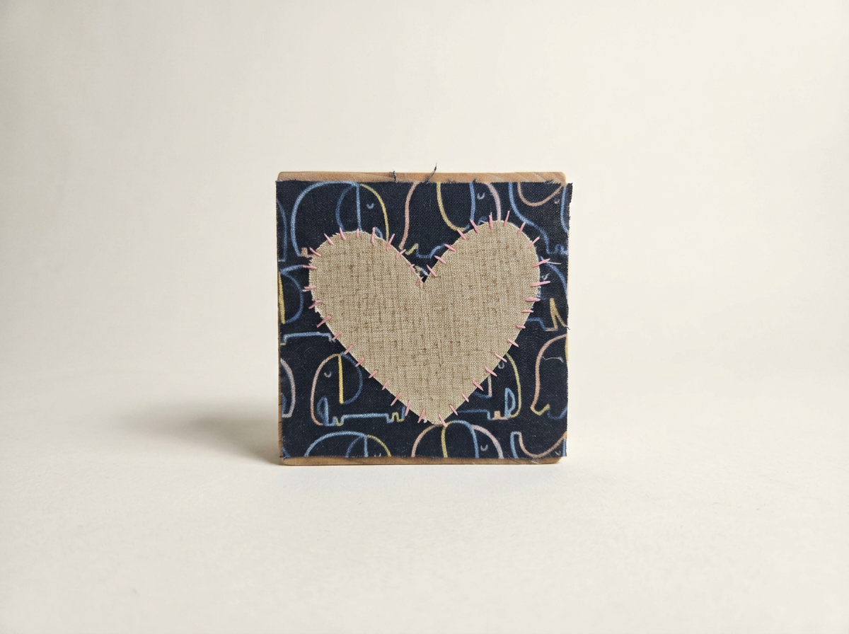 Elephants with a beige heart made of wood