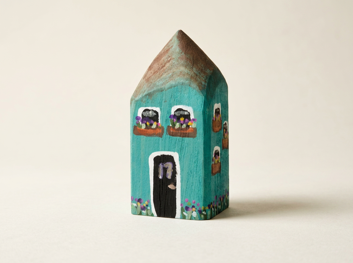 Teal wood house with 17 on the door