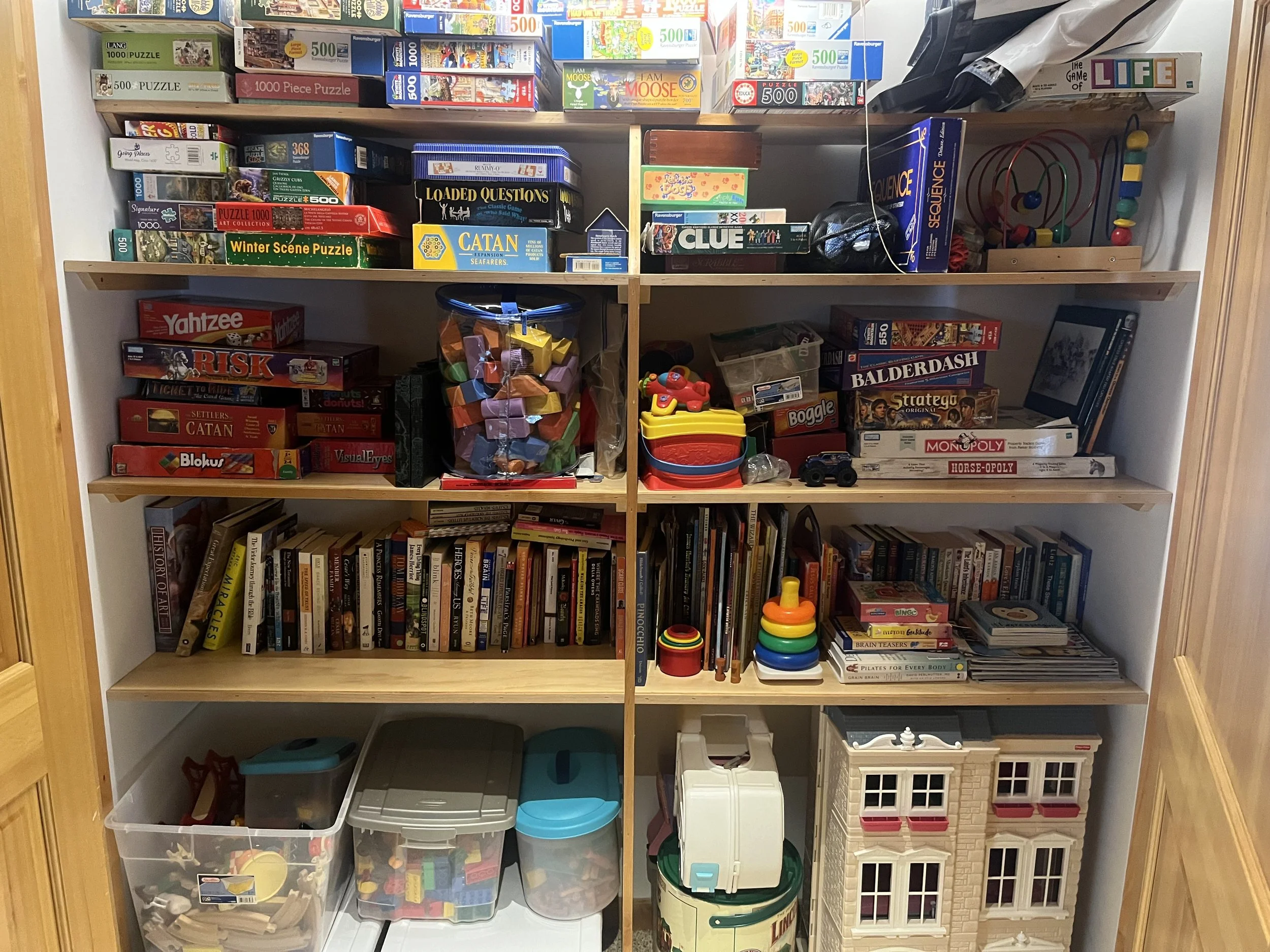 A large cabinet in Estes vacation home filled with board games, puzzles, toys, and books for all ages.
