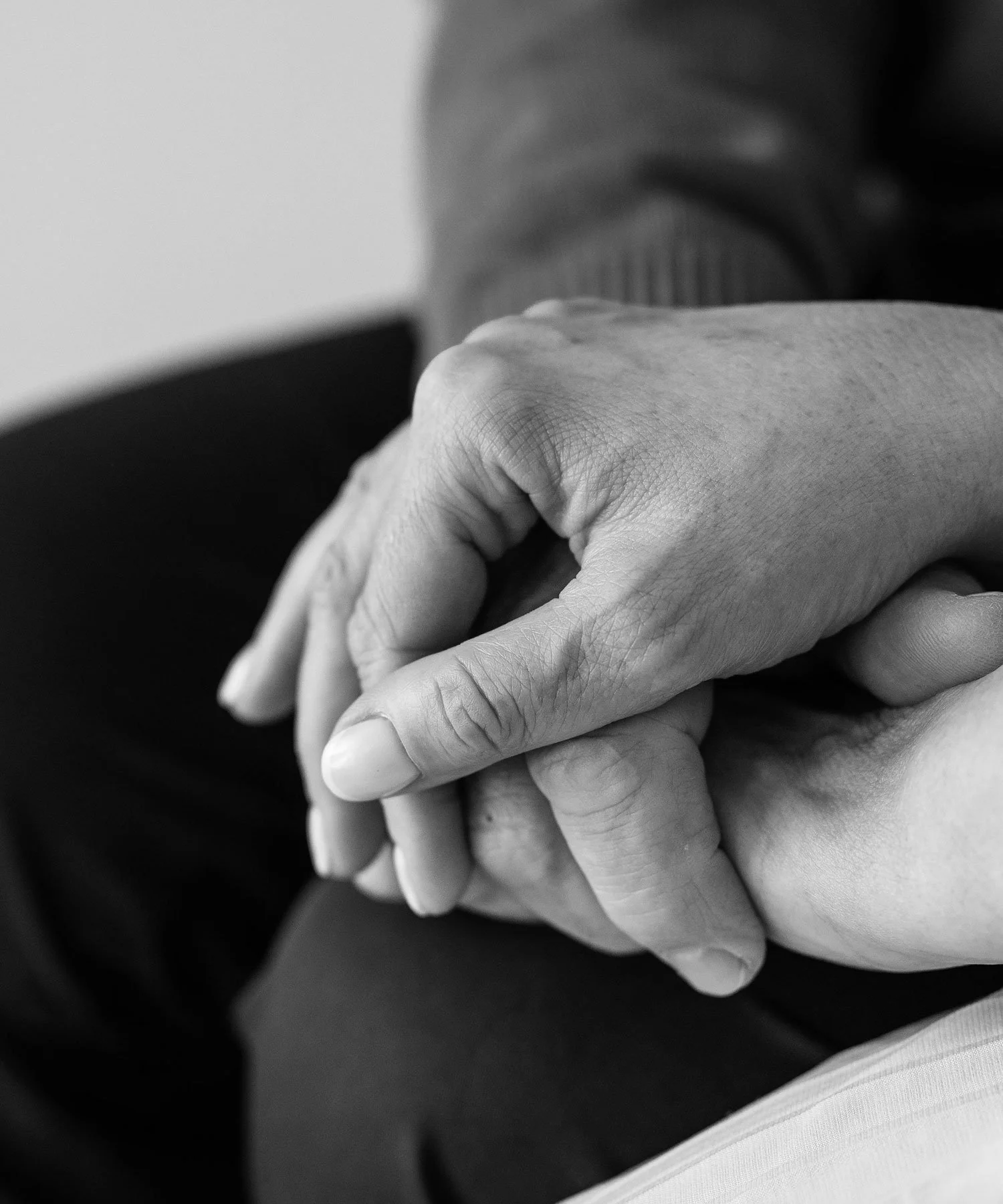 Black and white image of hands embracing.