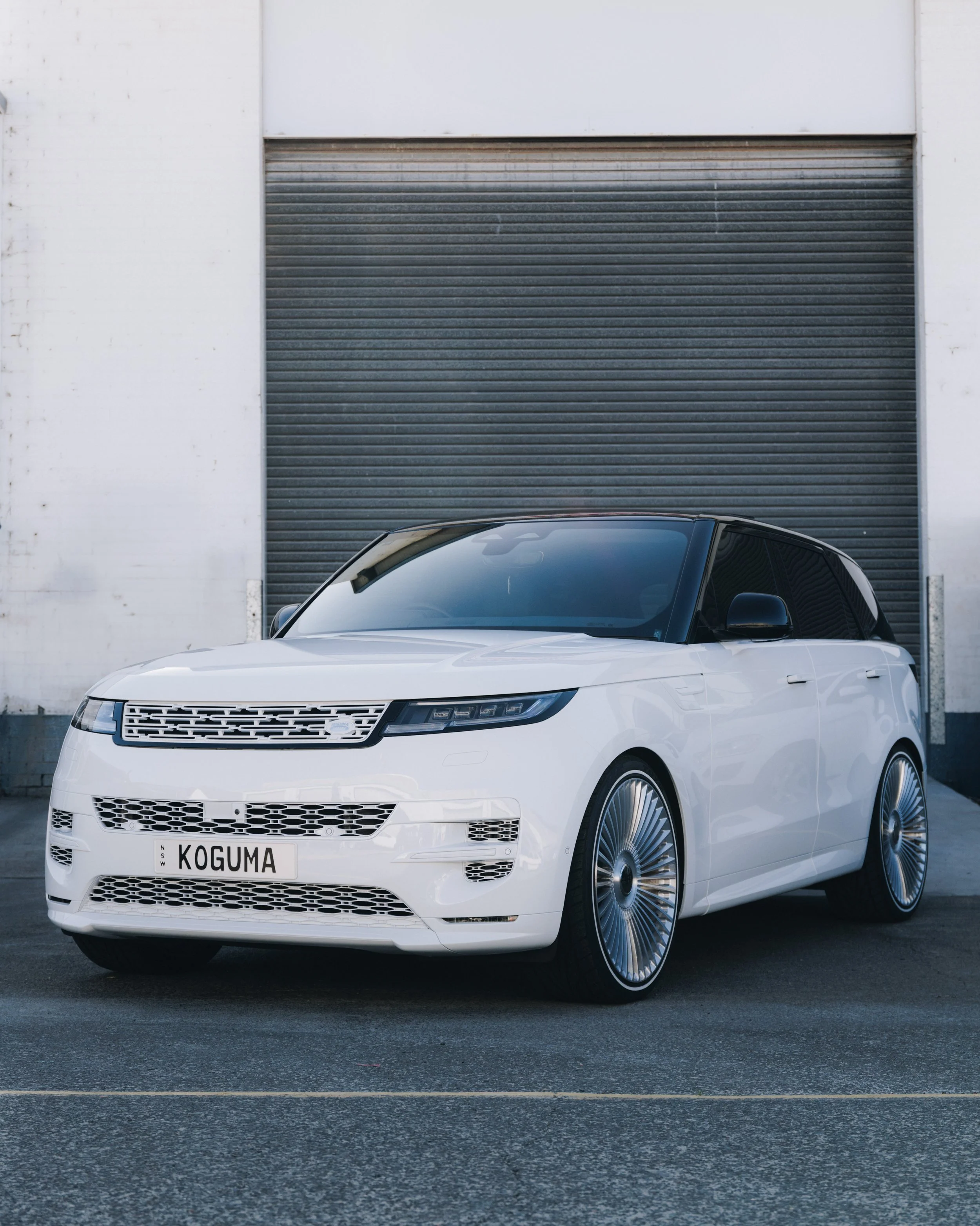 White luxury range rover SUV parked outside Koguma Garage in Wollongong, showcasing our custom automotive paint, bodywork, custom wheels, and premium vehicle customisation services.
