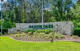 Marion Oaks community entrance sign with greenery and trees in the background