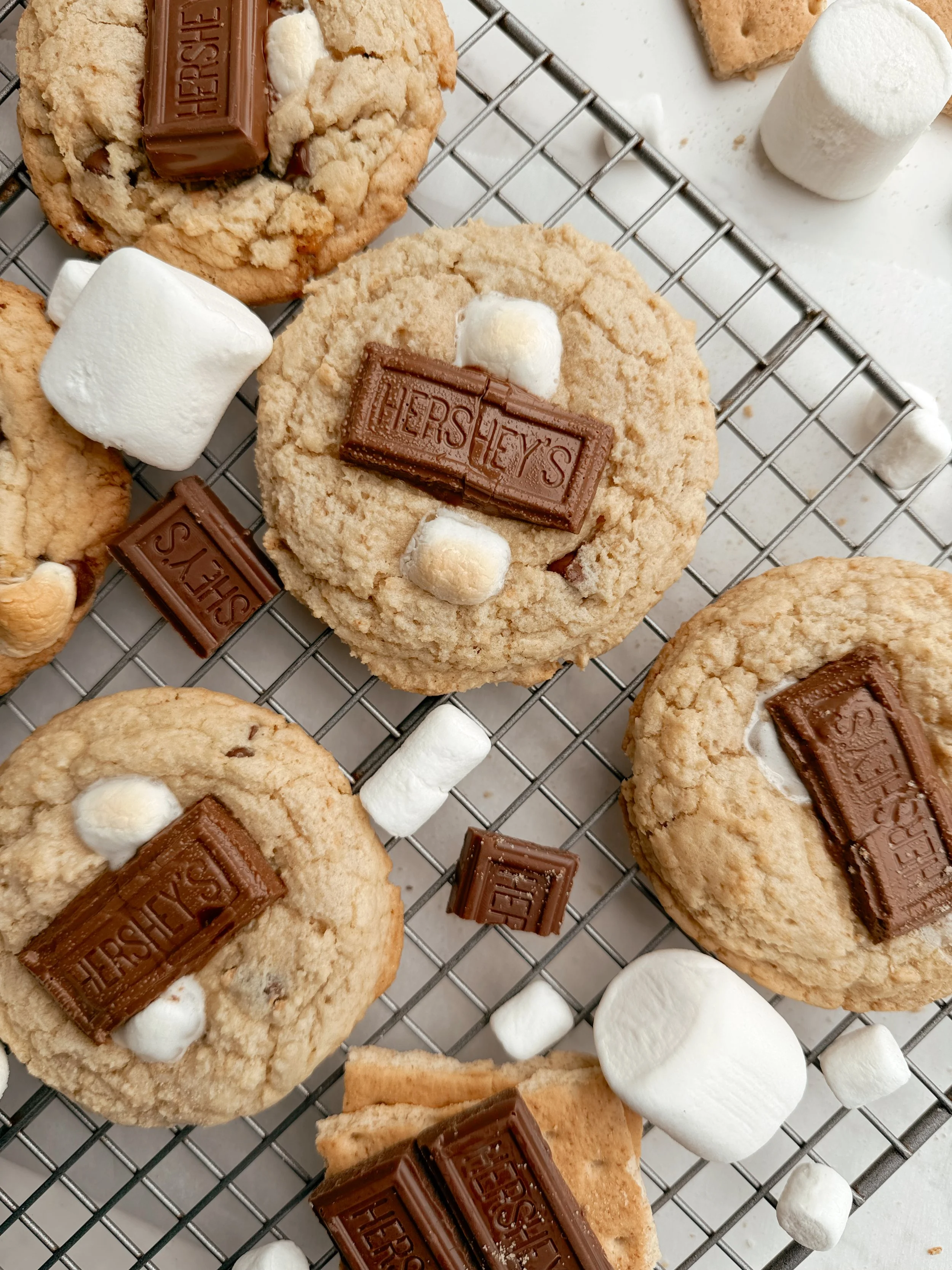 Smores cookies with gooey marshmallow and melted chocolate on parchment paper