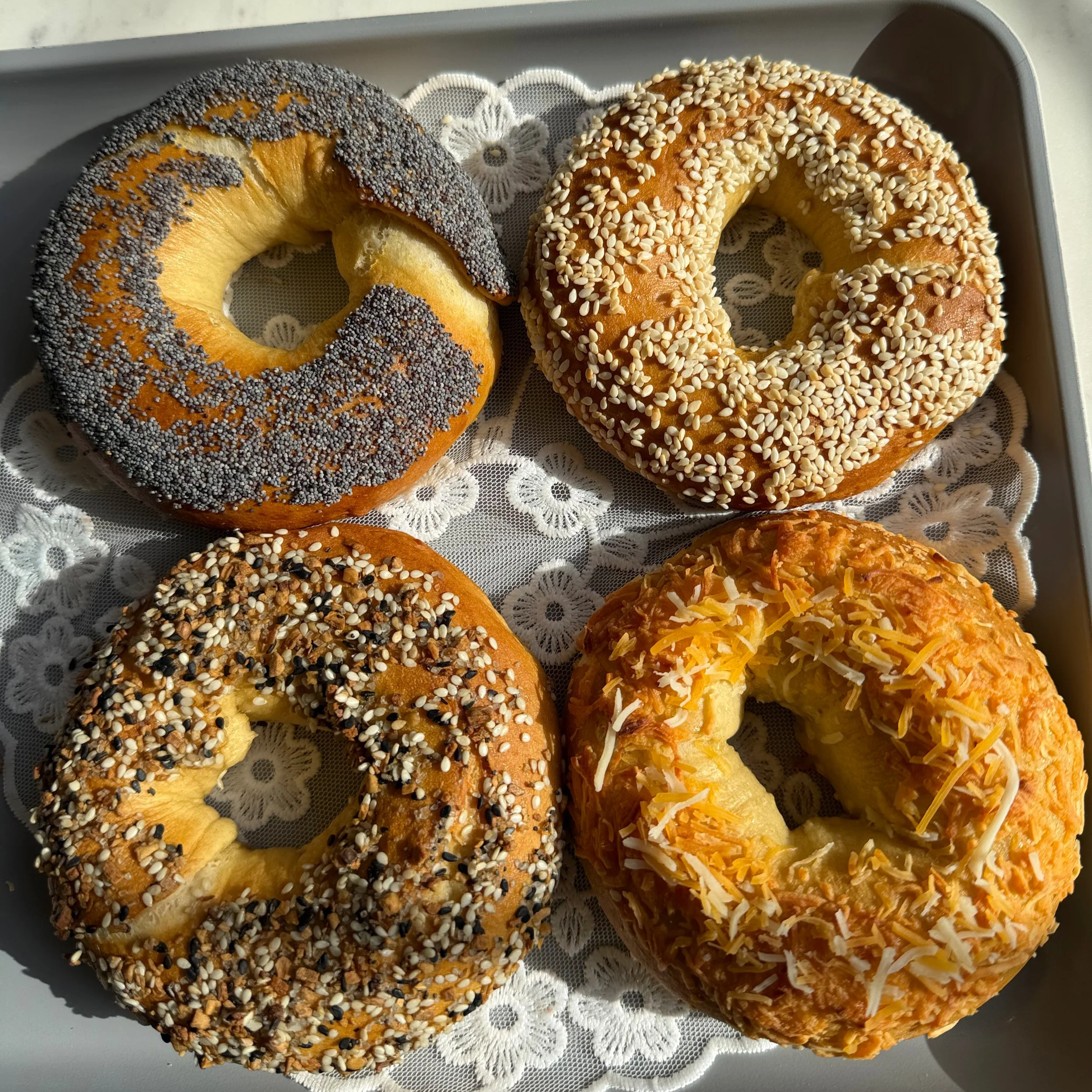 Close up  of 4 bagels on baking sheet