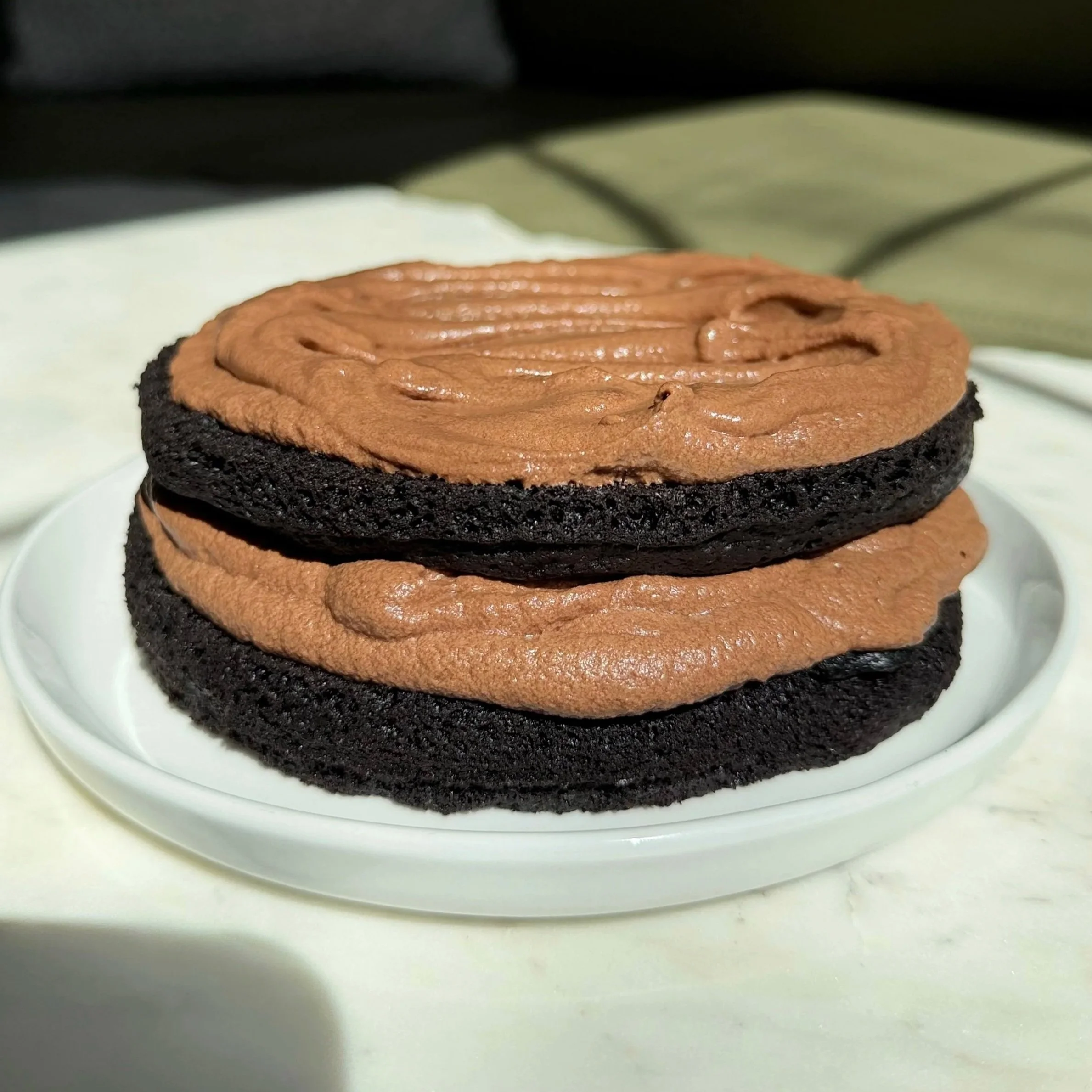 mini chocolate cake with glossy chocolate ganache on a small dessert plate