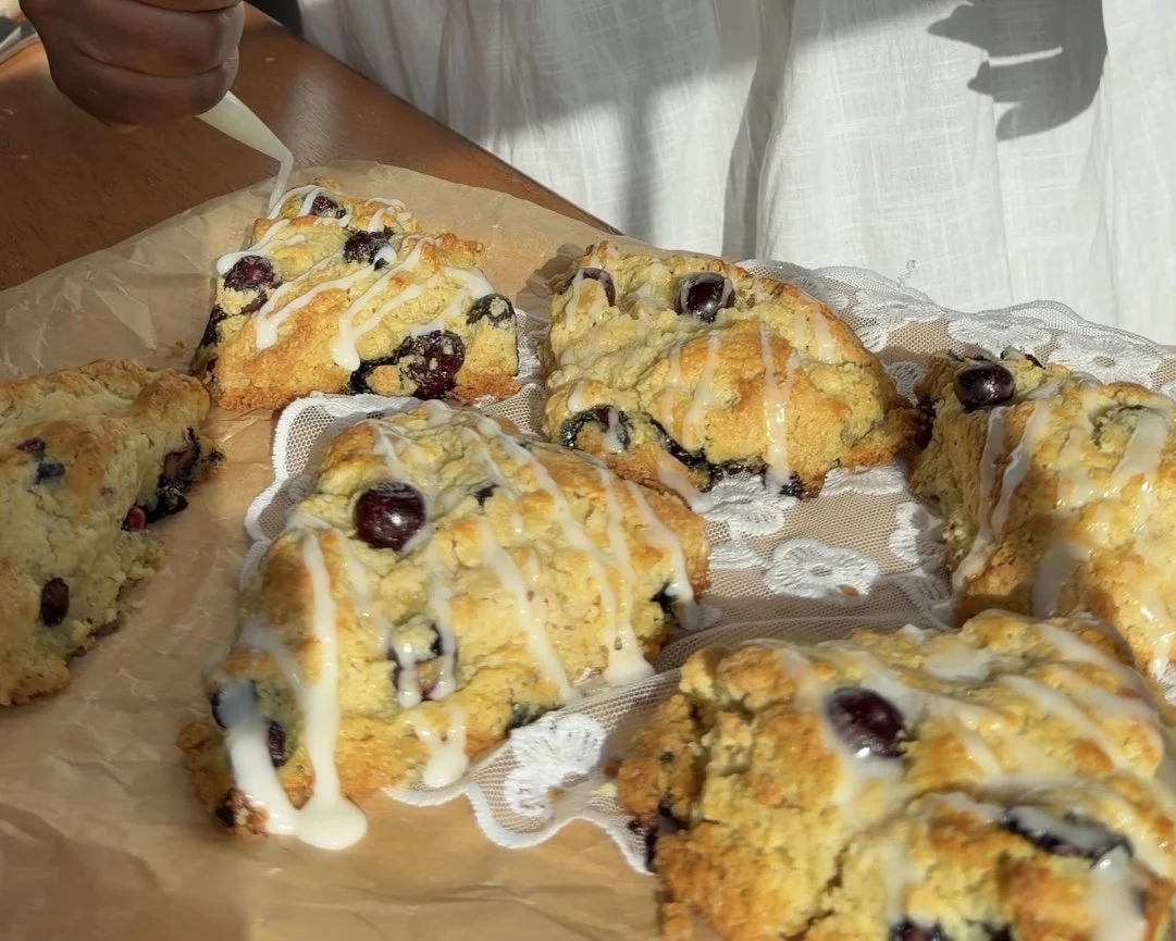 lemon blueberry scones with glaze on parchment paper