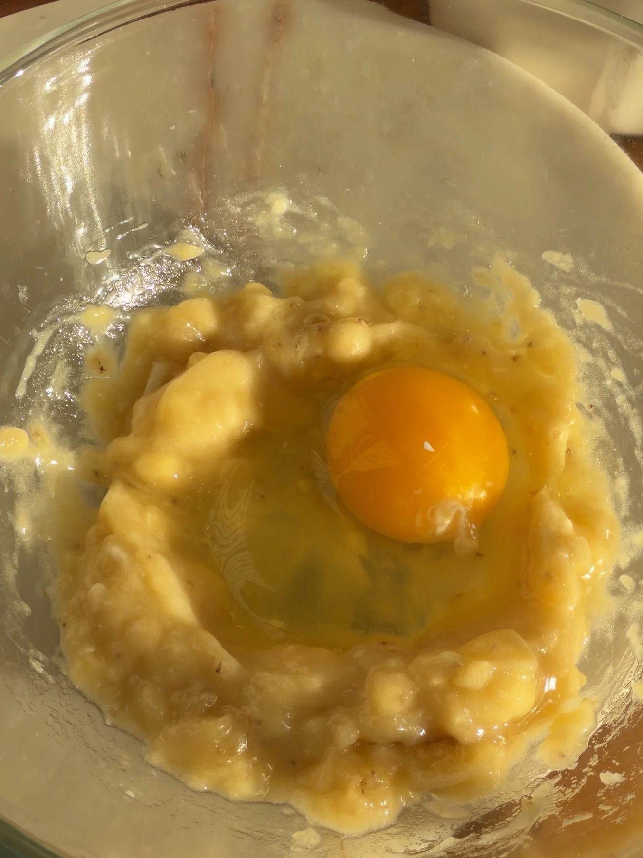 egg and banana being mixed in mixing bowl
