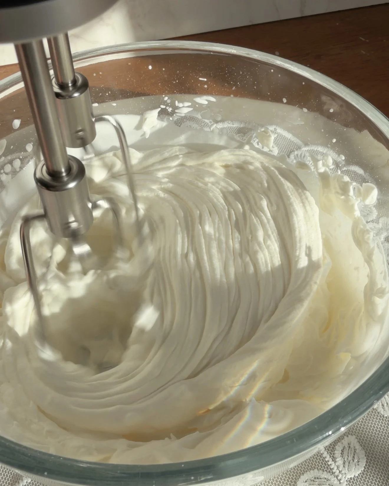 electric hand mixer whipping heavy cream and sugar mixture