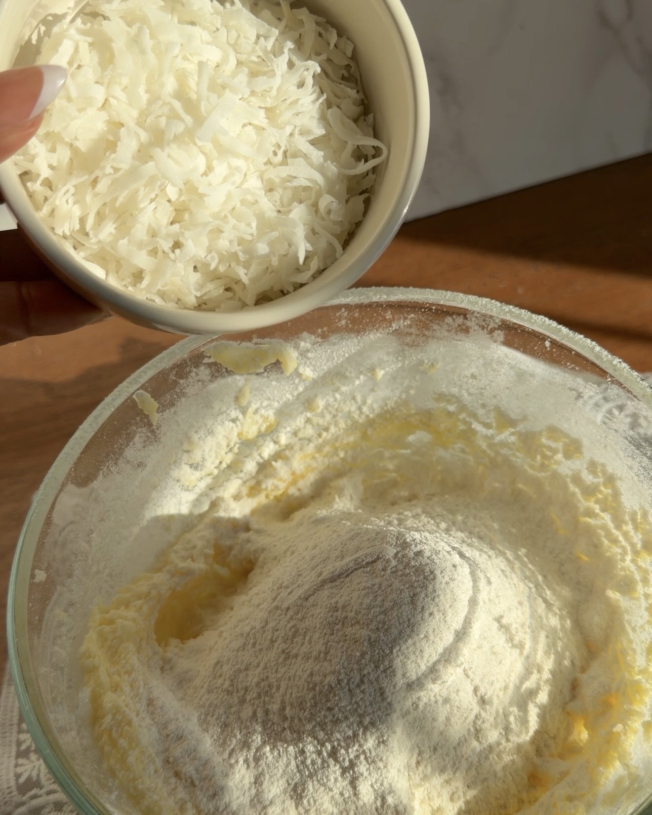 Coconut flakes being added to cake batter