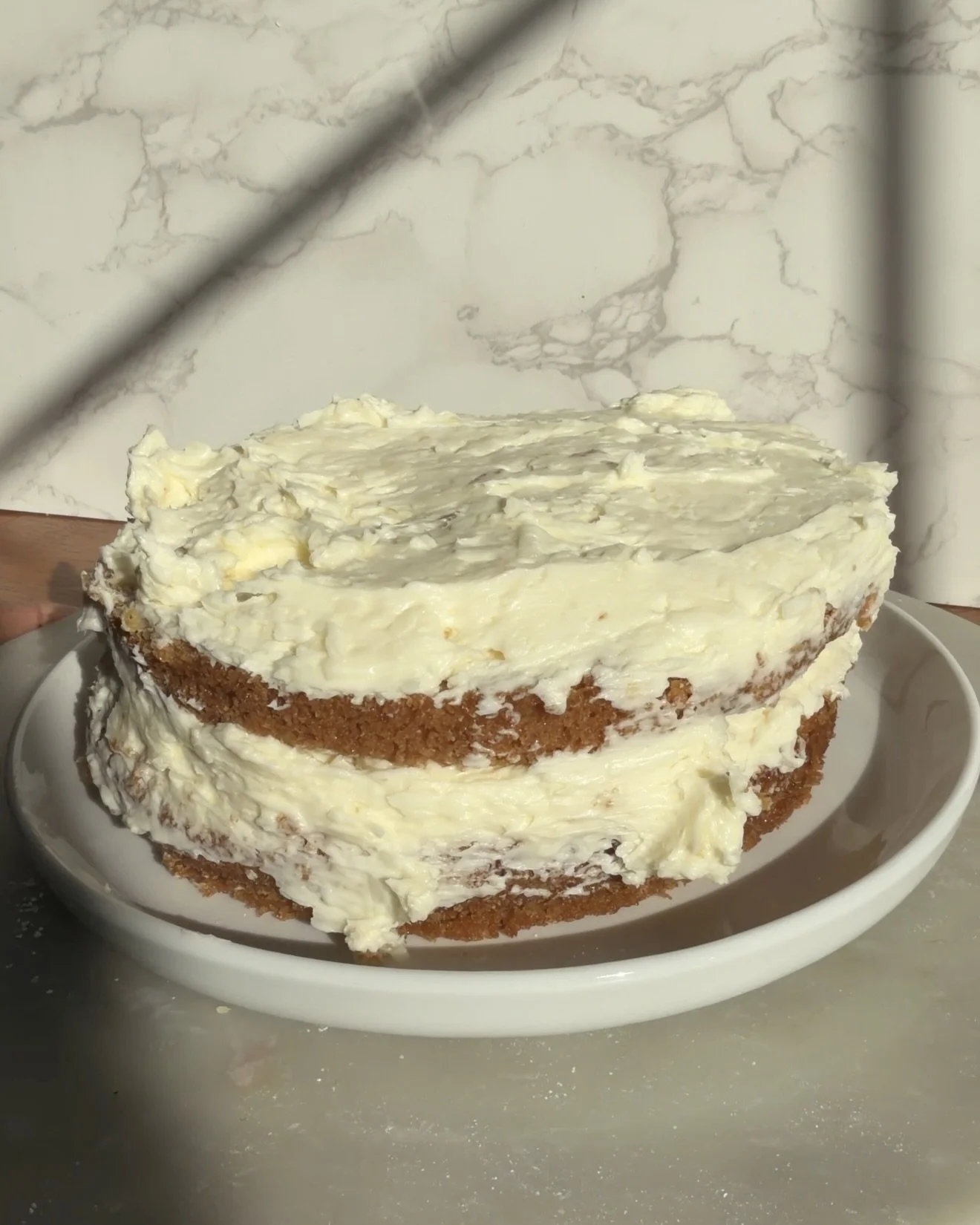 Second layer of cake with frosting on the counter