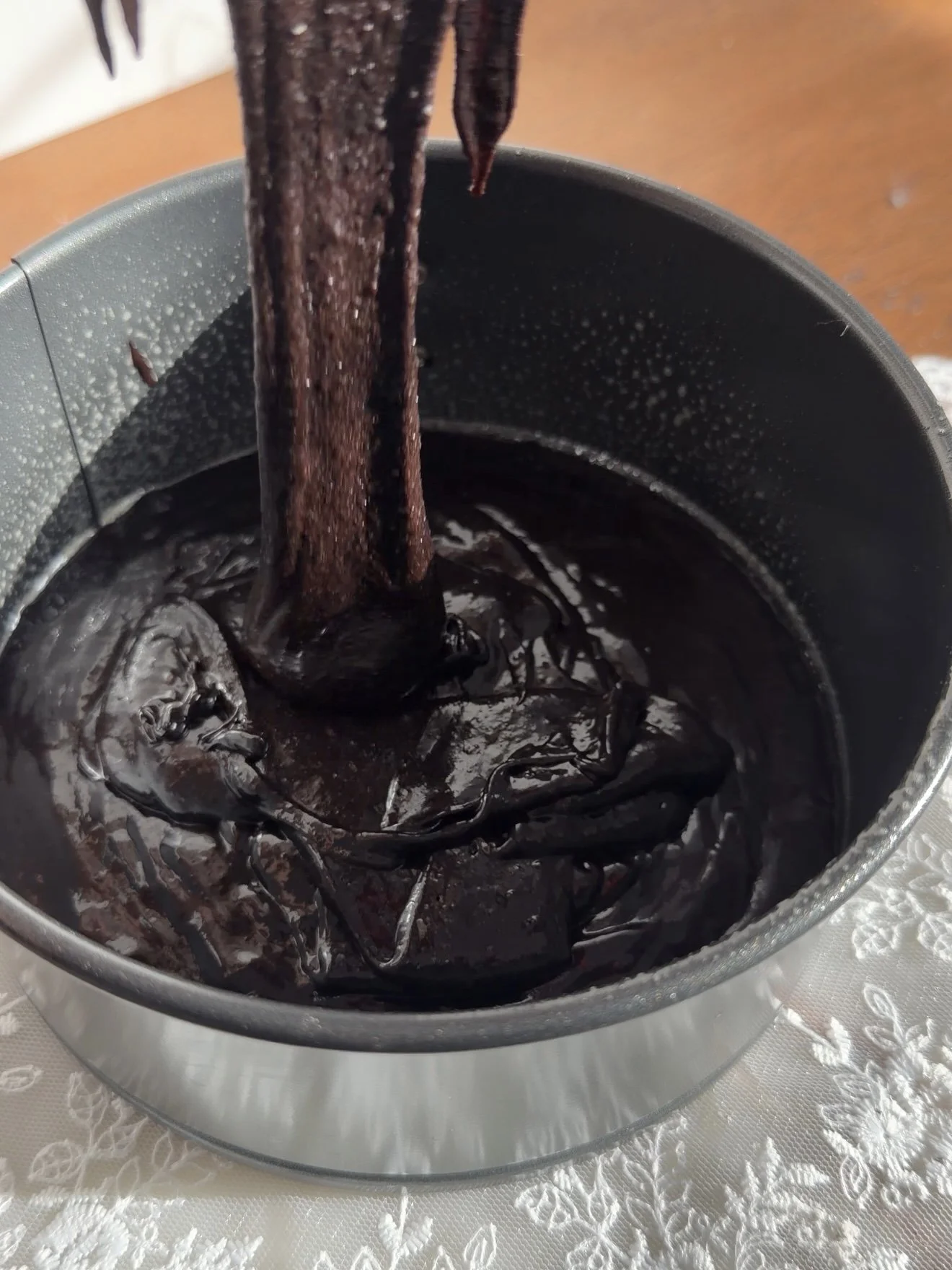Chocolate cake  batter being poured into six inch baking pan