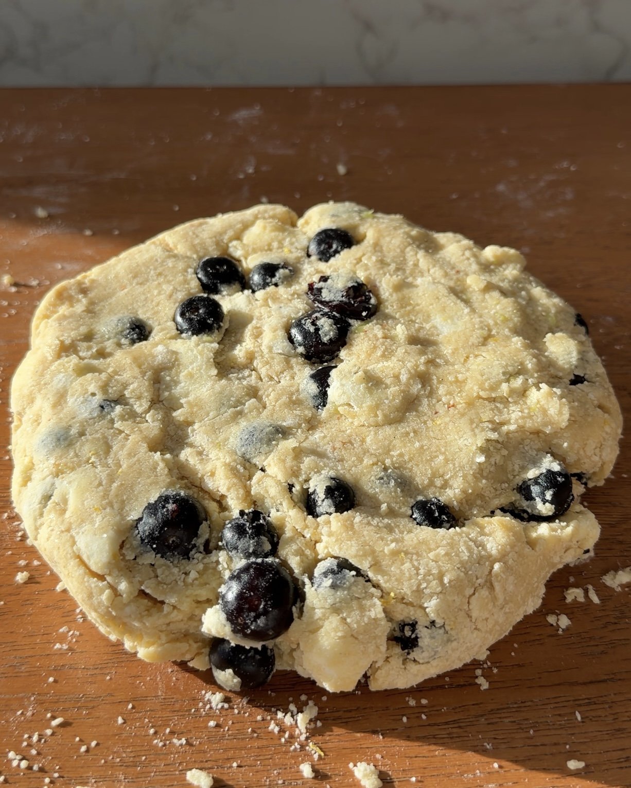 Scone dough mixture shaped into 6-8 inch disk on countertop