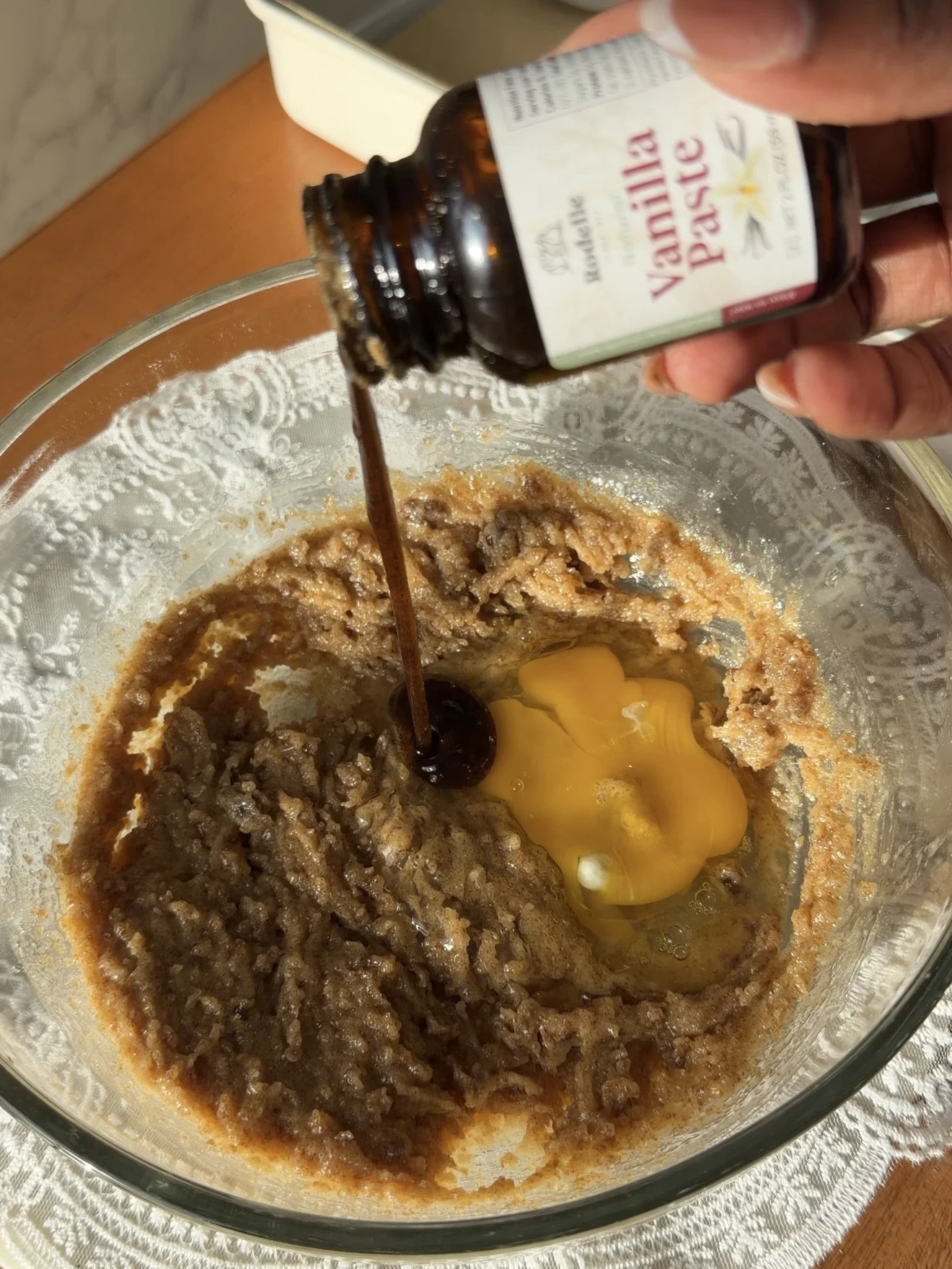 vanilla bean paste being added to wet ingredients