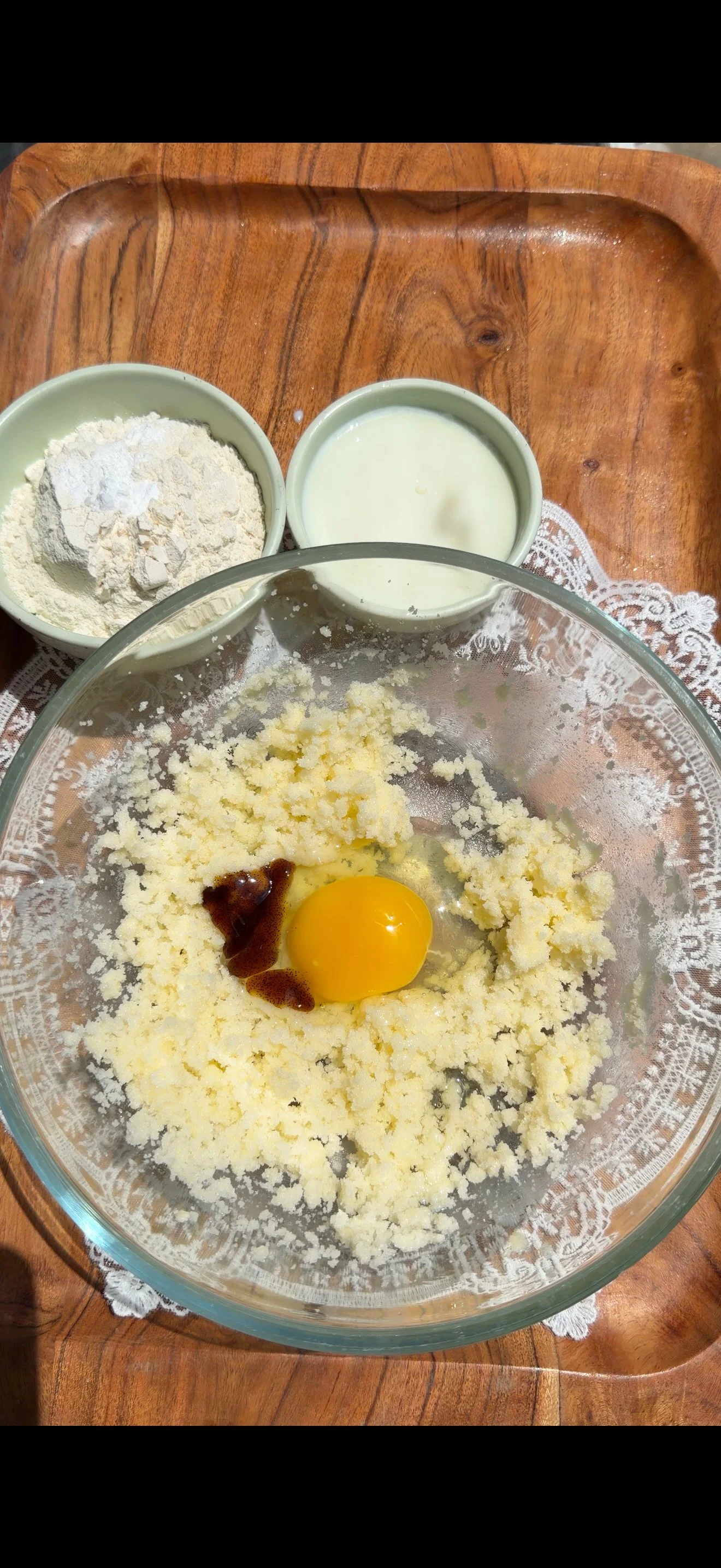Egg and vanilla bean paste mixed with wet ingredients in bowl 