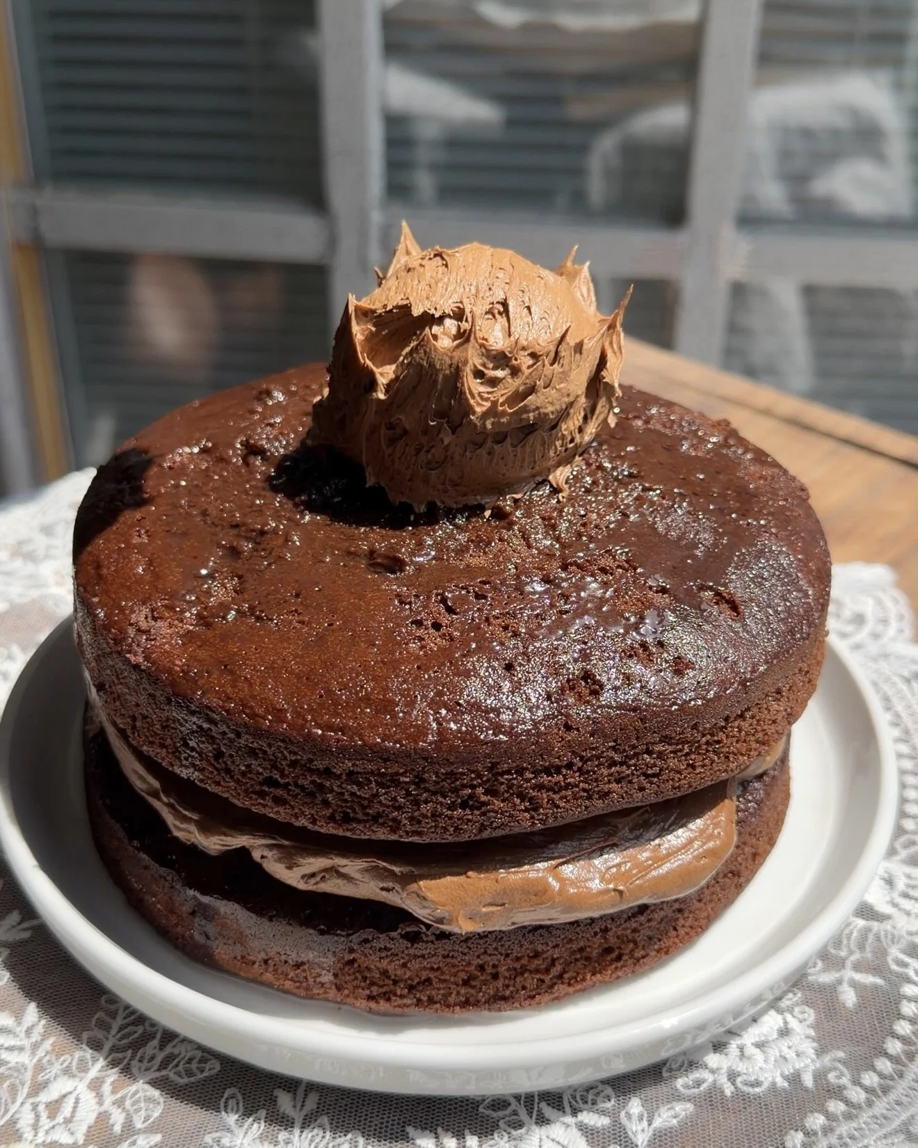 Close up of a rich chocolate layer cake with soft chocolate cake layers and frosting