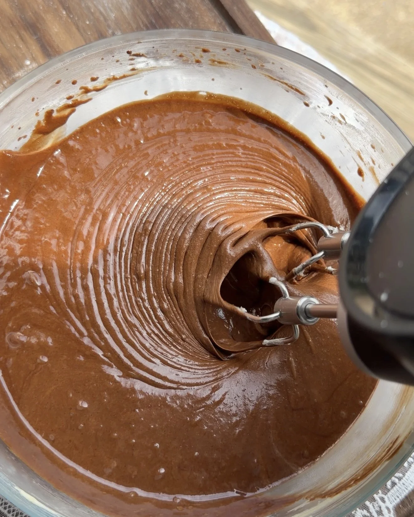 Chocolate cake batter mixed in glass mixing bowl. 