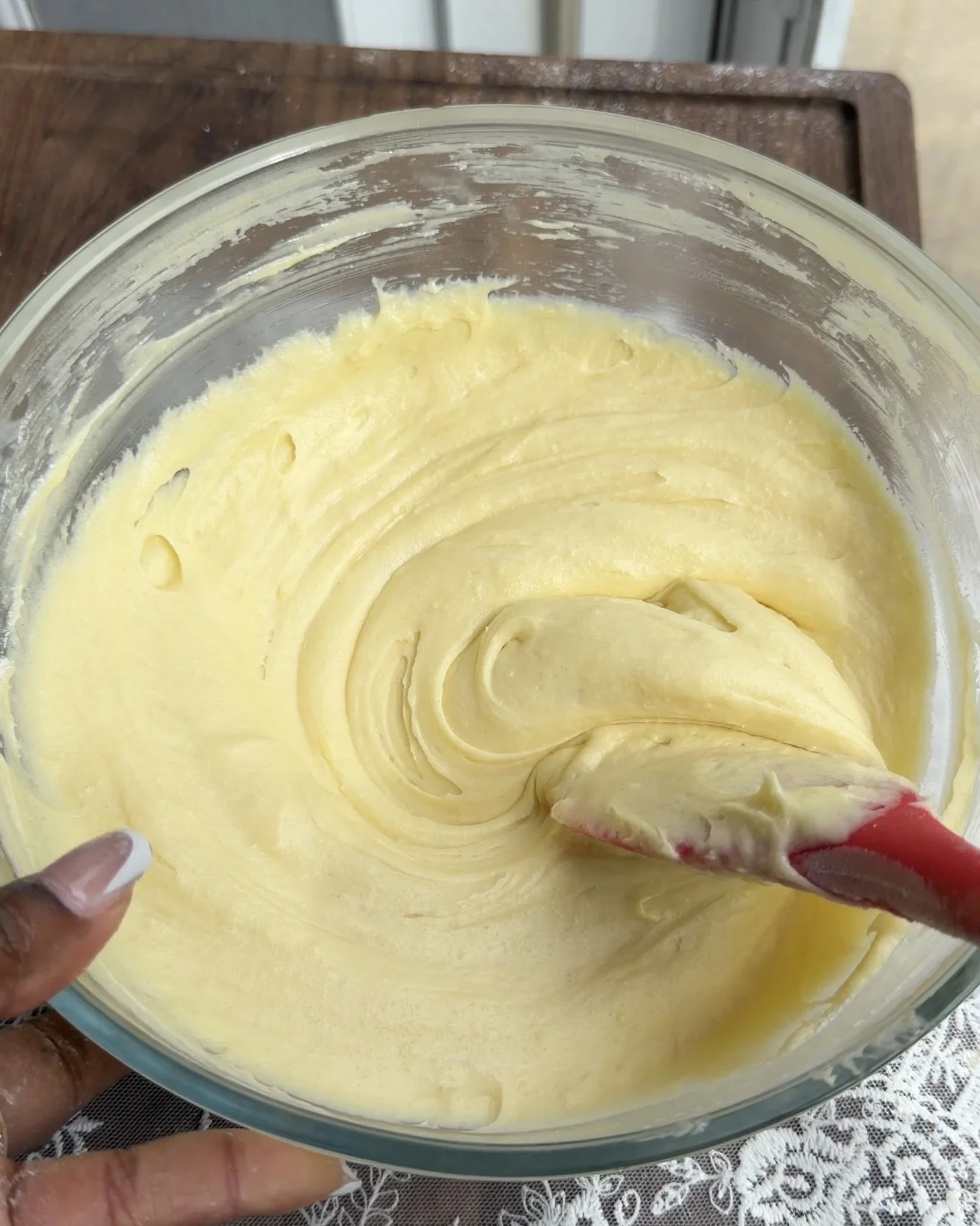 Yellow cake batter mixture in glass mixing bowl