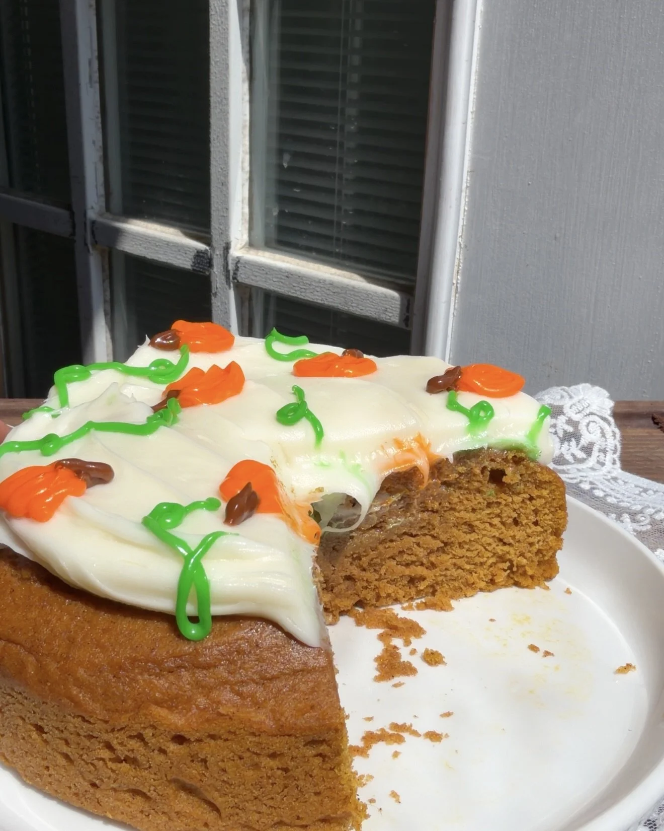 Slice taken out of Mini pumpkin cake with creamy cream cheese frosting and warm fall spices