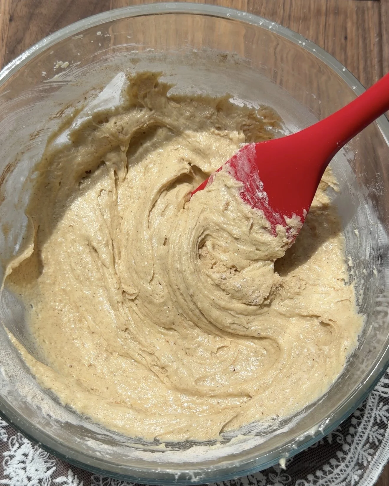 Glass mixing bowl with cake batter and red spatula