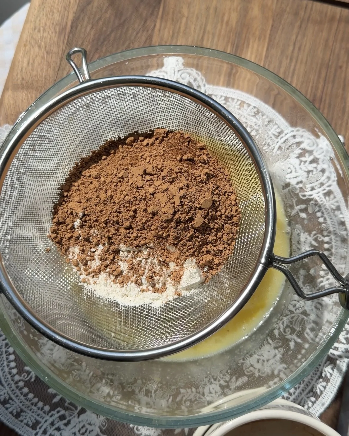 Cocoa powder and flour sifted into wet ingredients. 
