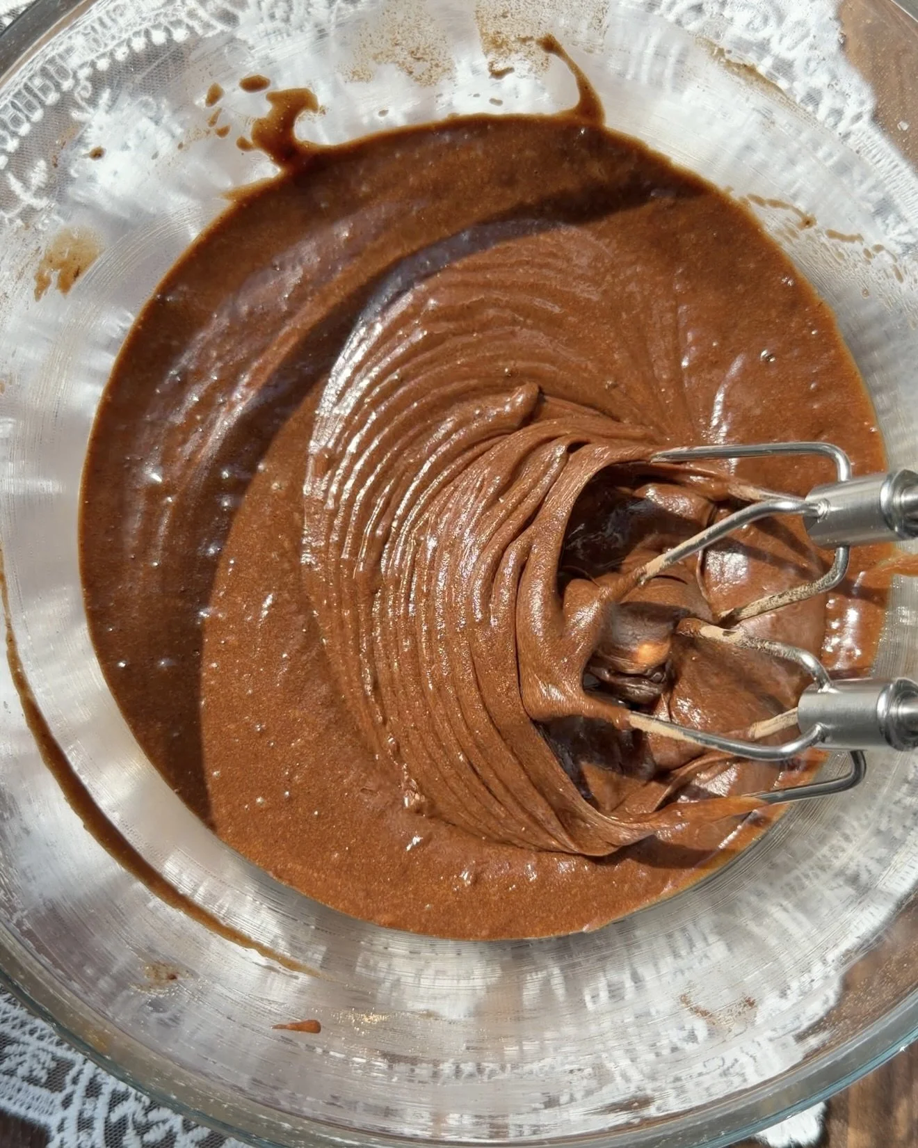 Chocolate cake batter mixed in glass mixing bowl. 