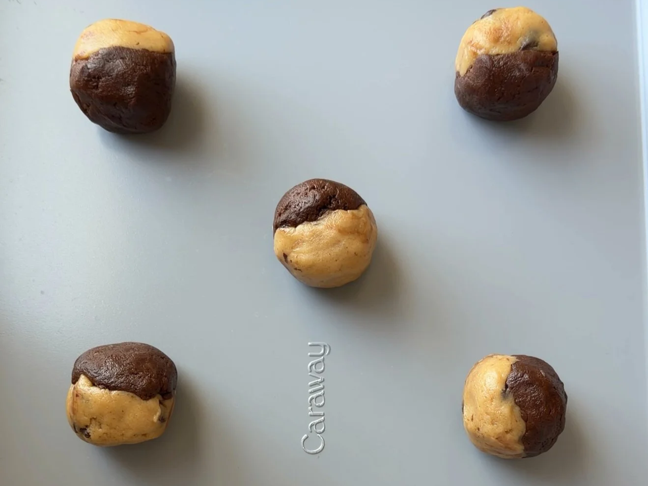 Brookie cookies baked with brownie and chocolate chip dough swirled together on baking sheet