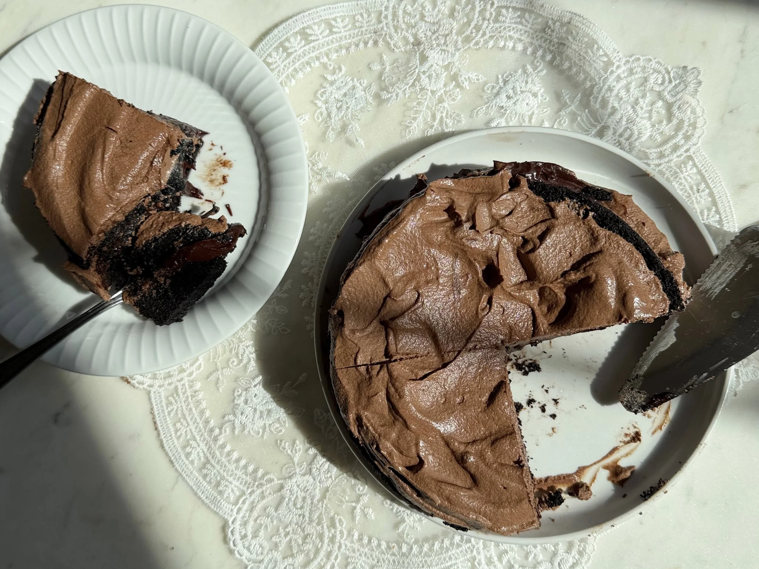 mini chocolate cake with glossy chocolate ganache on a small dessert plate