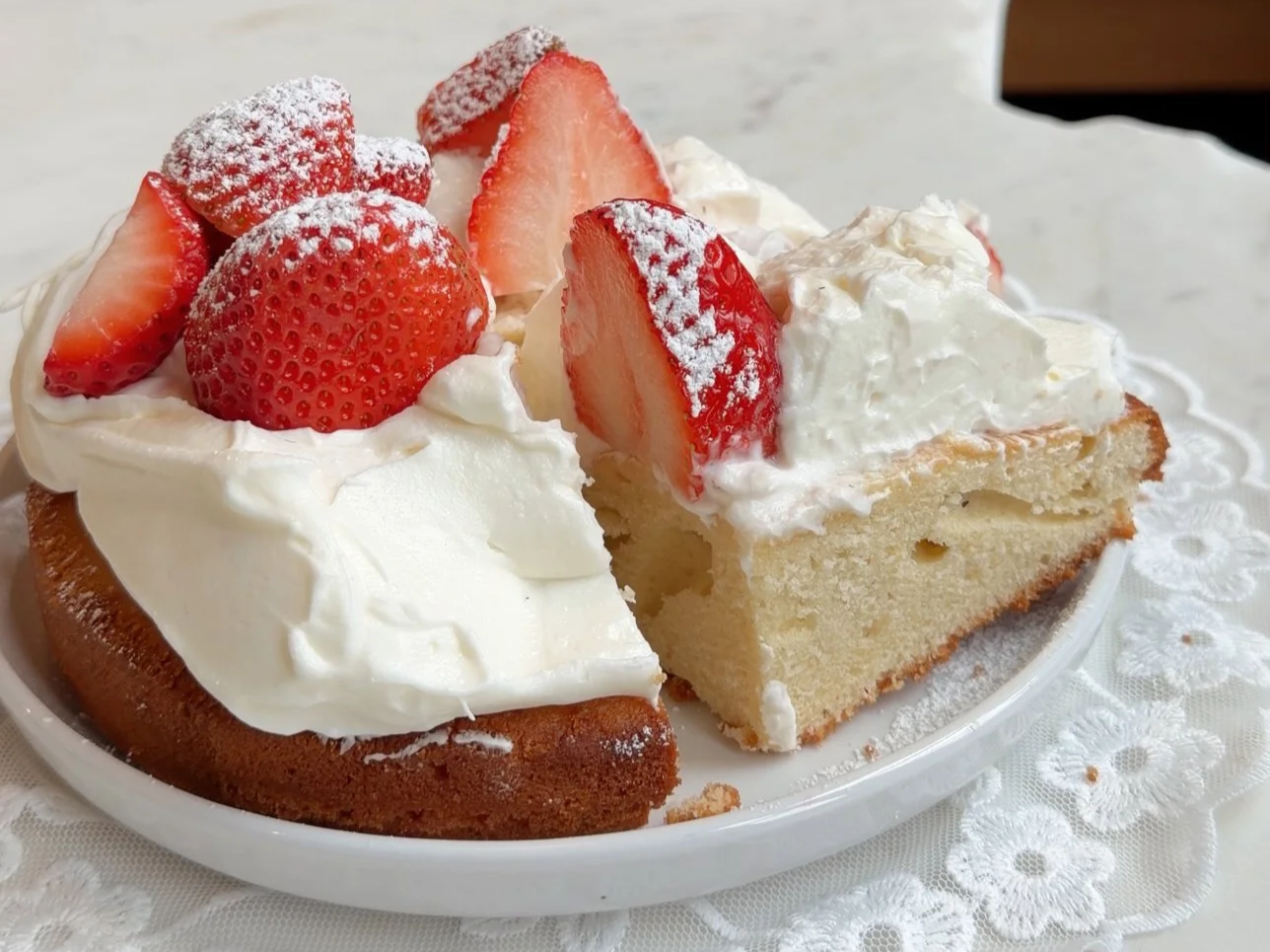 Mini strawberry shortcake topped with fresh whipped cream and sliced strawberries