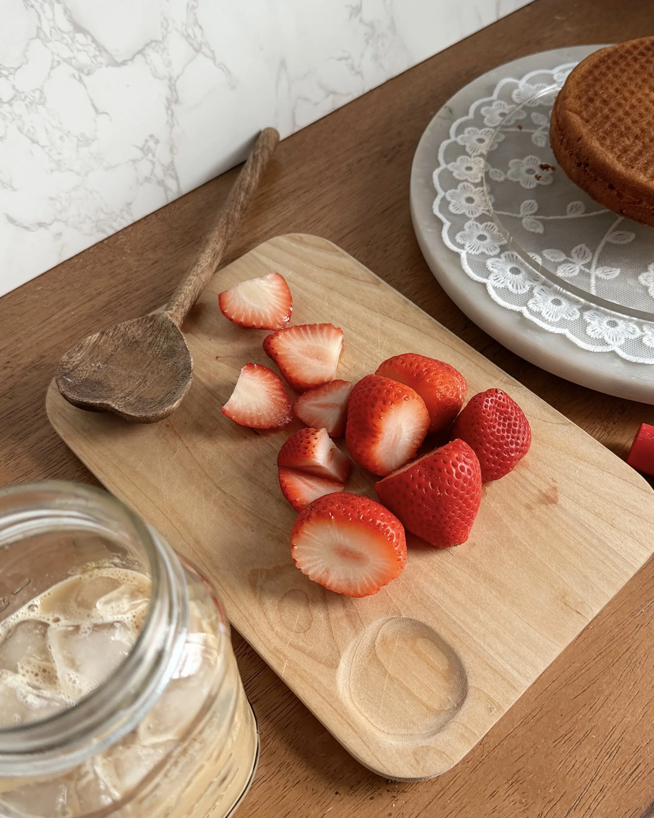 chopped up strawberries on a wood cutting board on the countertop
