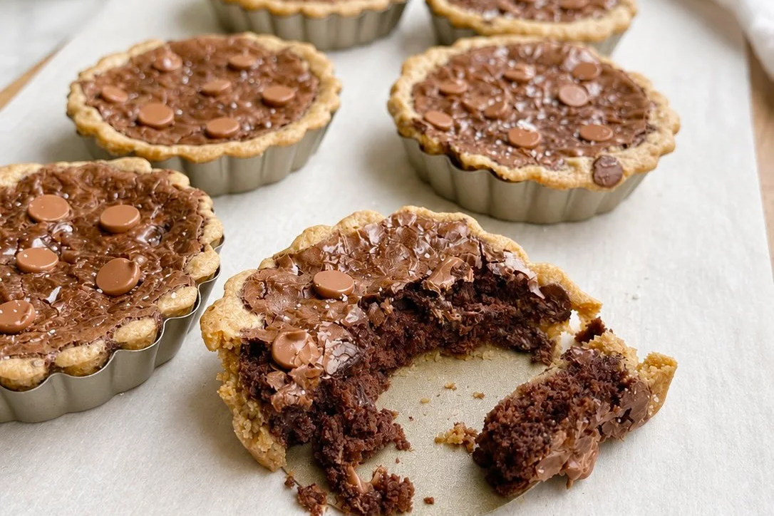 Close up of brookie tarts on white parchment.