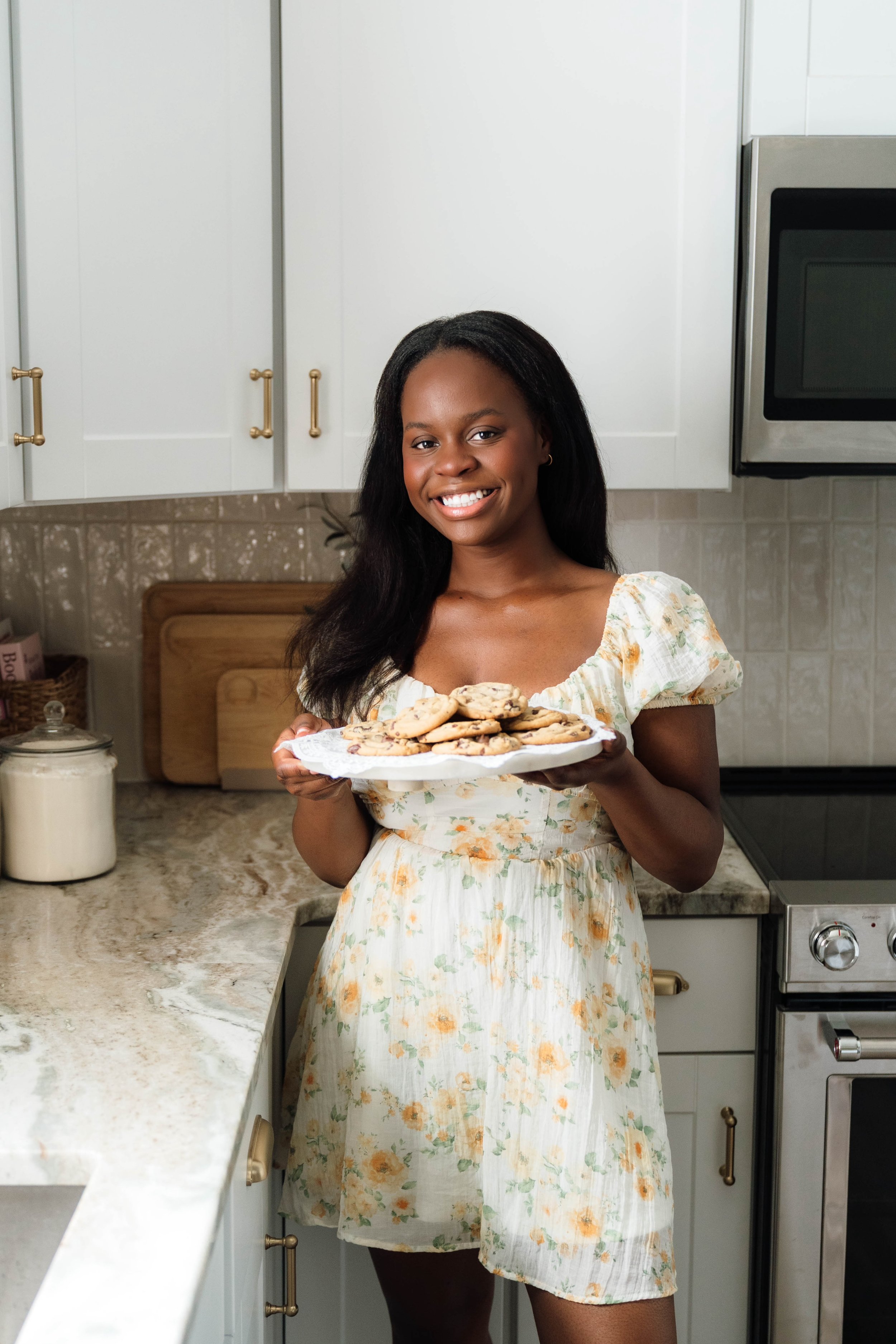 headshot of Samantha Chen in the kitchen holding a plate of chocolate chip cookies