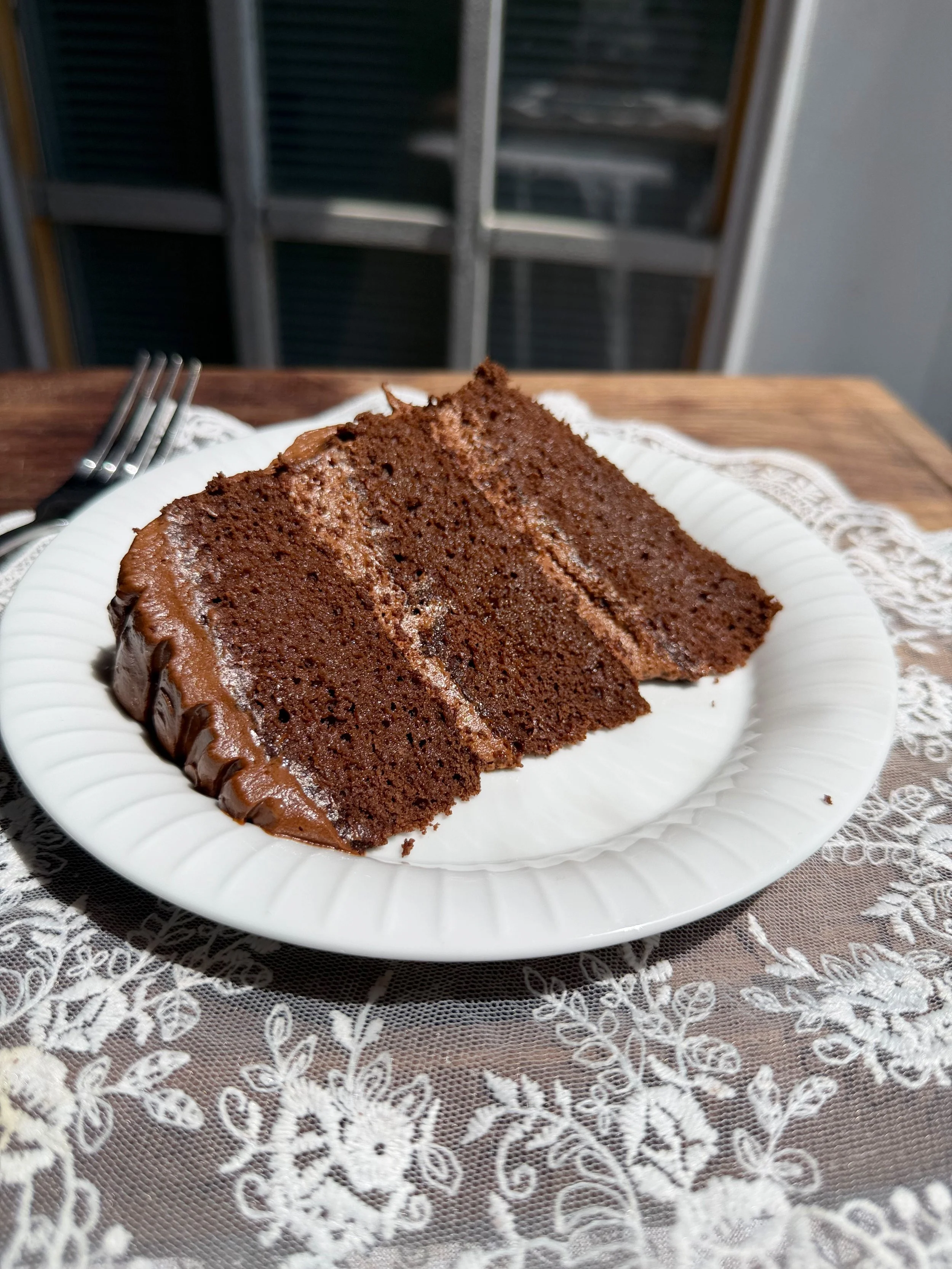 5 ingredient chocolate cake stacked into three chocolate cake layers with chocolate frosting