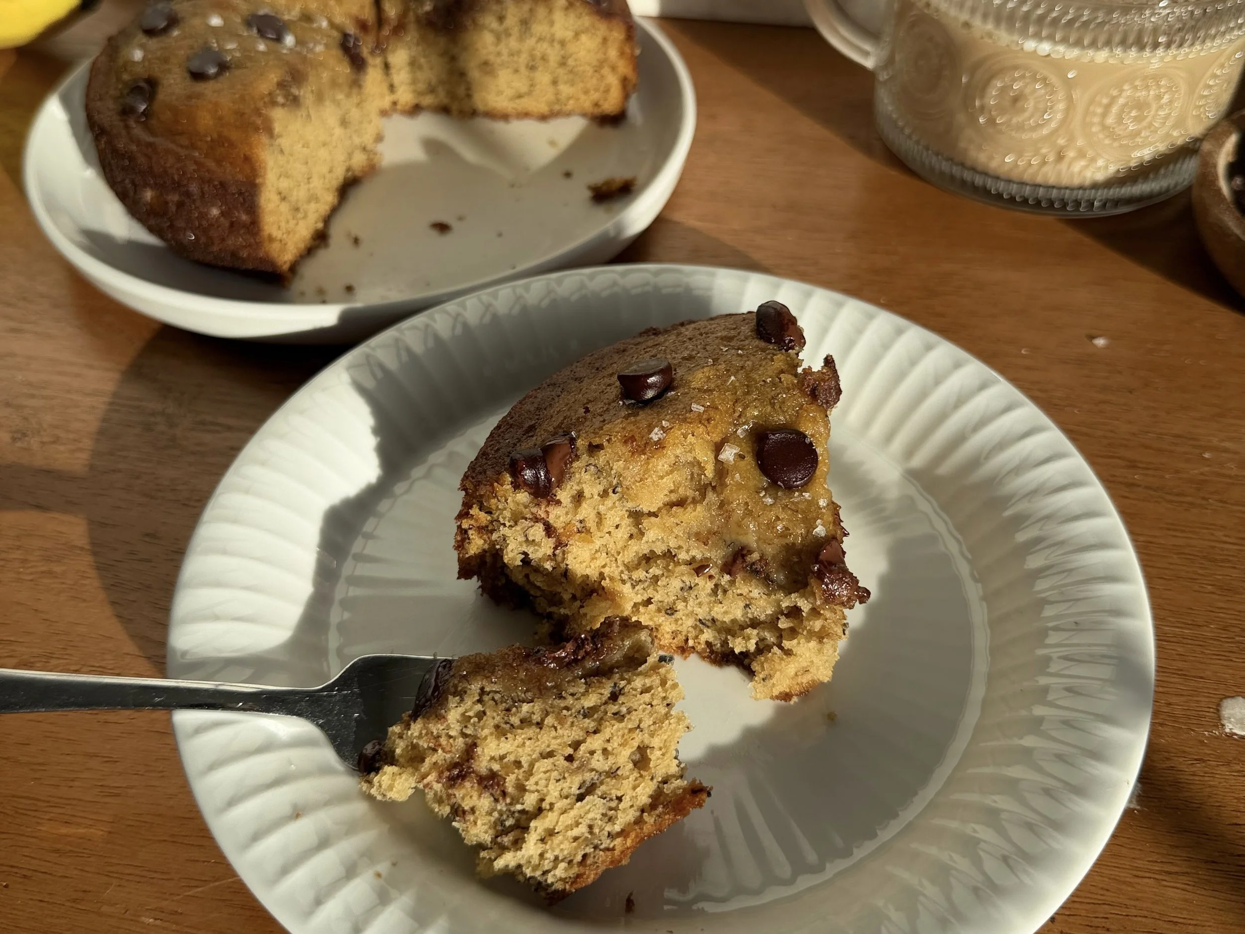 Slice of banana bread on white plate on counter